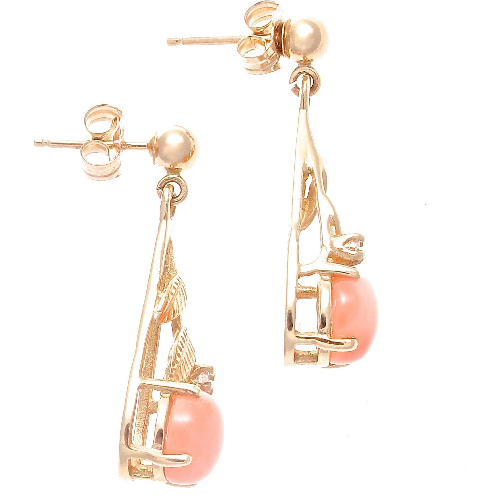 A creative and attractive pair of earrings that can be worn anytime.. Featuring angel skin button coral drops that hang from 14k gold accented by a single near colorless diamond. 