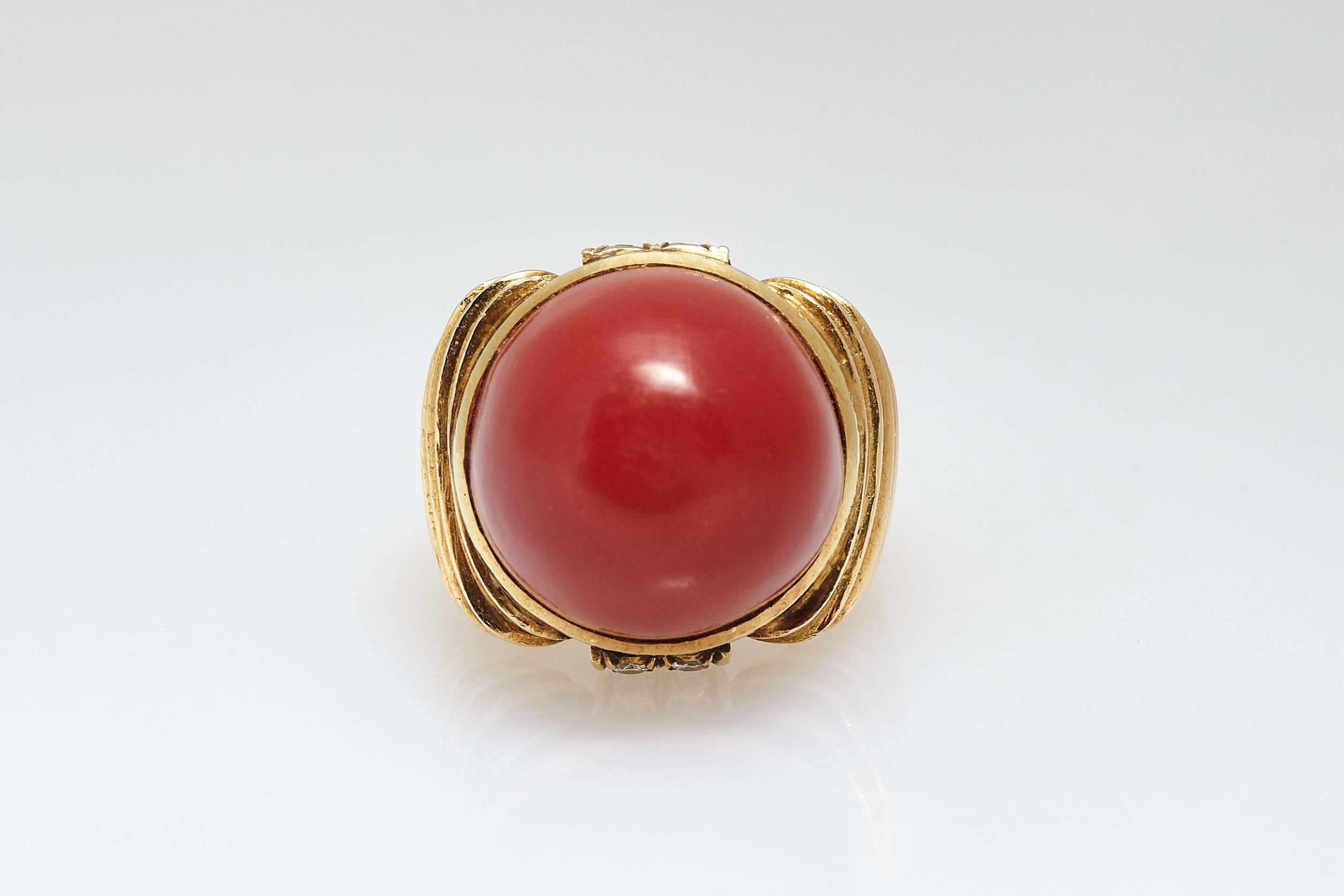 An impressive 18kt yellow gold cocktail ring showcasing a fine red coral dome shaped element, accented by small diamonds on the side. Made in Italy, circa 1970.