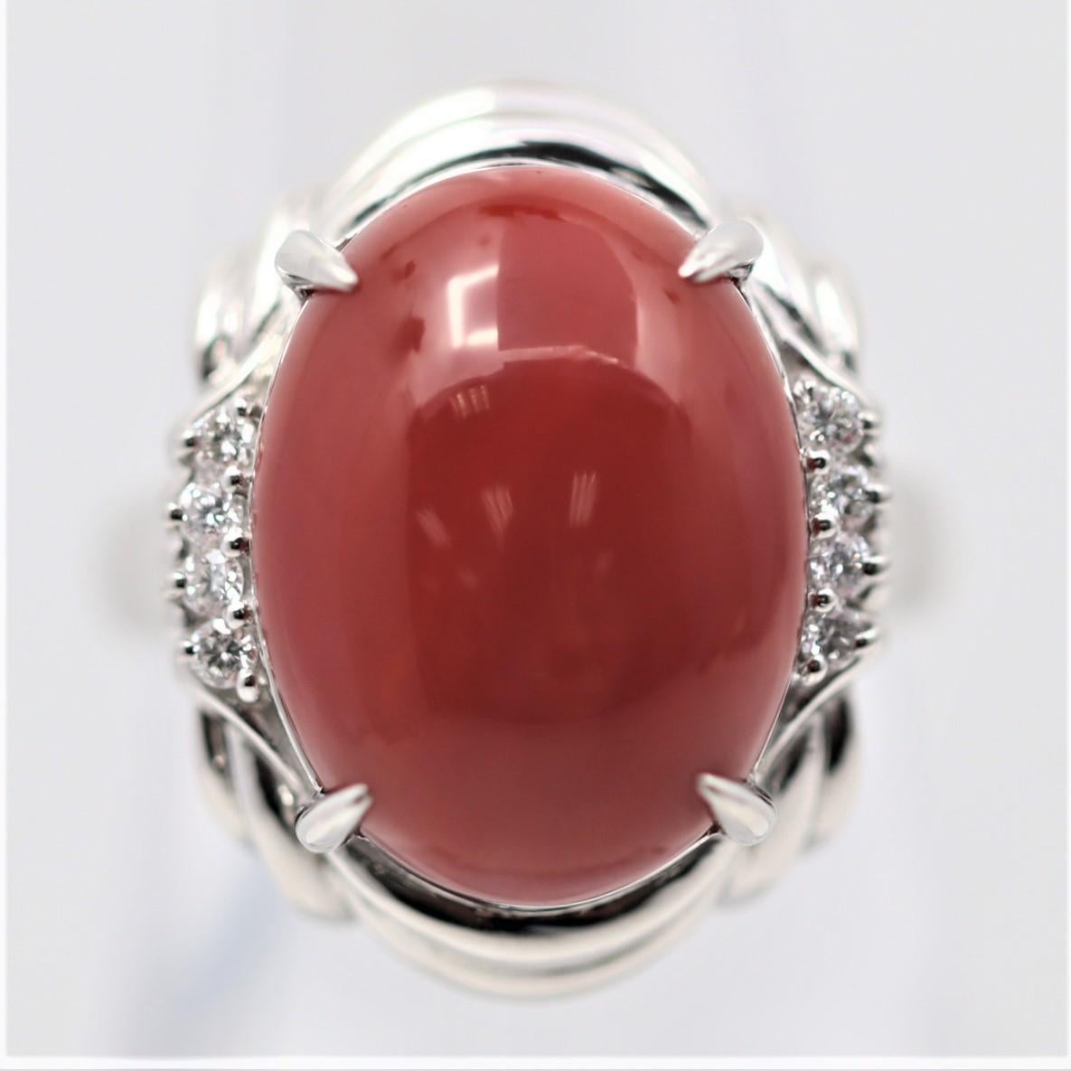 A stylish and sturdy platinum made ring featuring a lovely red coral. It has a rich deep color and a lovely oval cabochon shape. It is accented by 0.10 carats of round brilliant-cut diamonds which add brilliance and sparkle to the ring.
