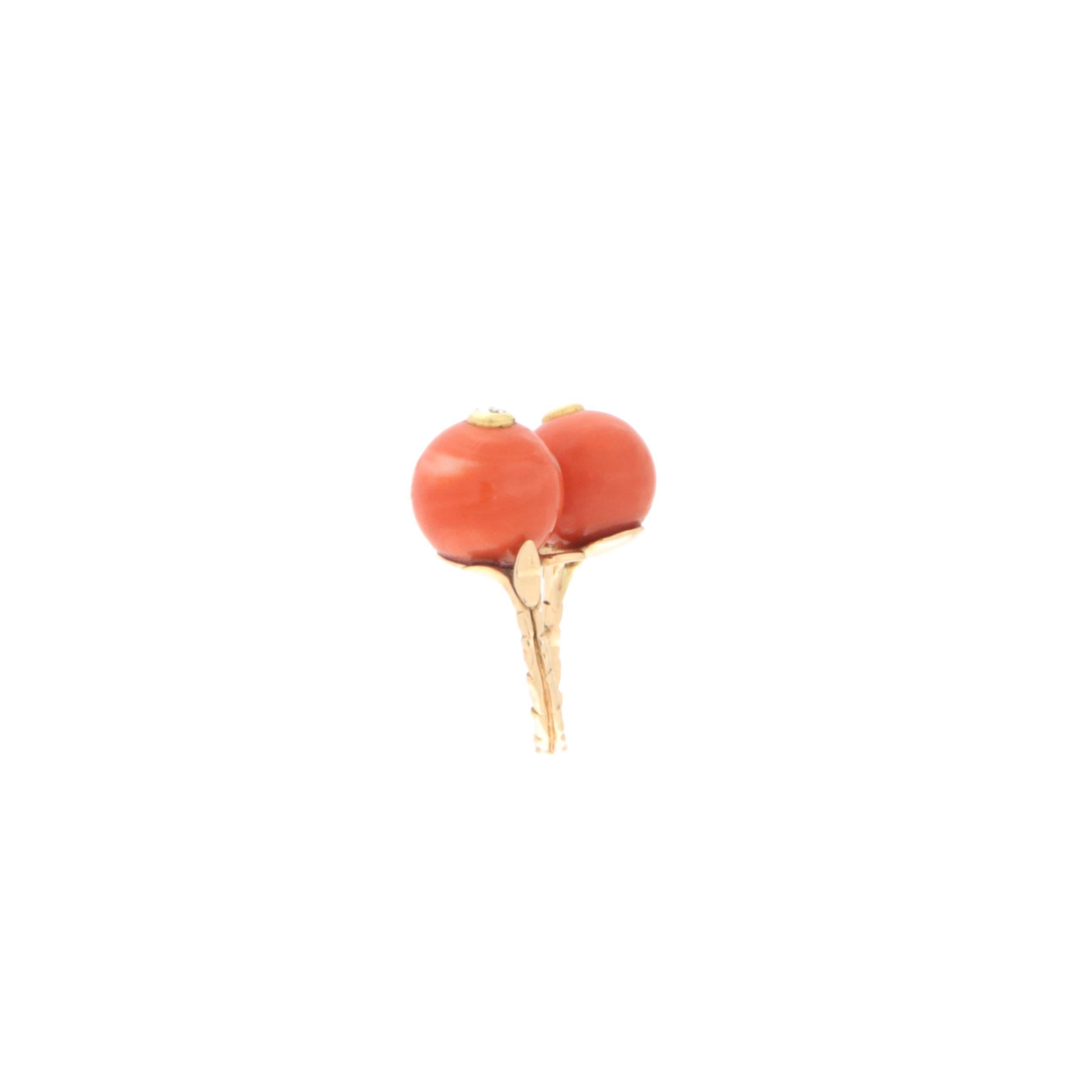 This extraordinary ring is crafted in fine 14K yellow gold, a symbol of sophistication and tradition. At the heart of its design are two stunning spheres of natural coral with a warm rosy hue, carefully selected for their exceptional quality and