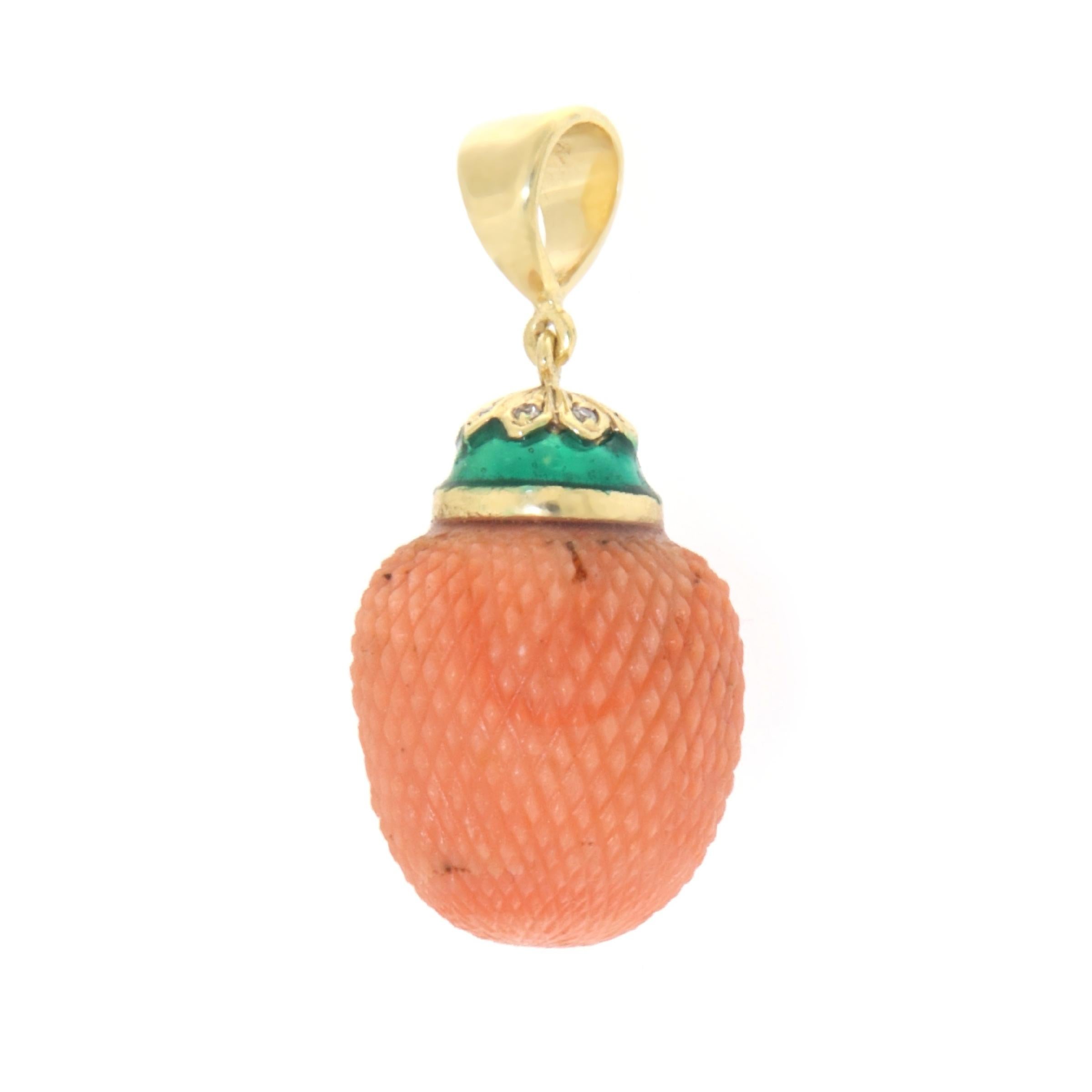 We present this charming acorn-shaped pendant, a unique creation made of 14 karat yellow gold. The design, inspired by nature, combines the elegance of the precious metal with the vibrancy of orange coral, masterfully carved to reproduce the texture