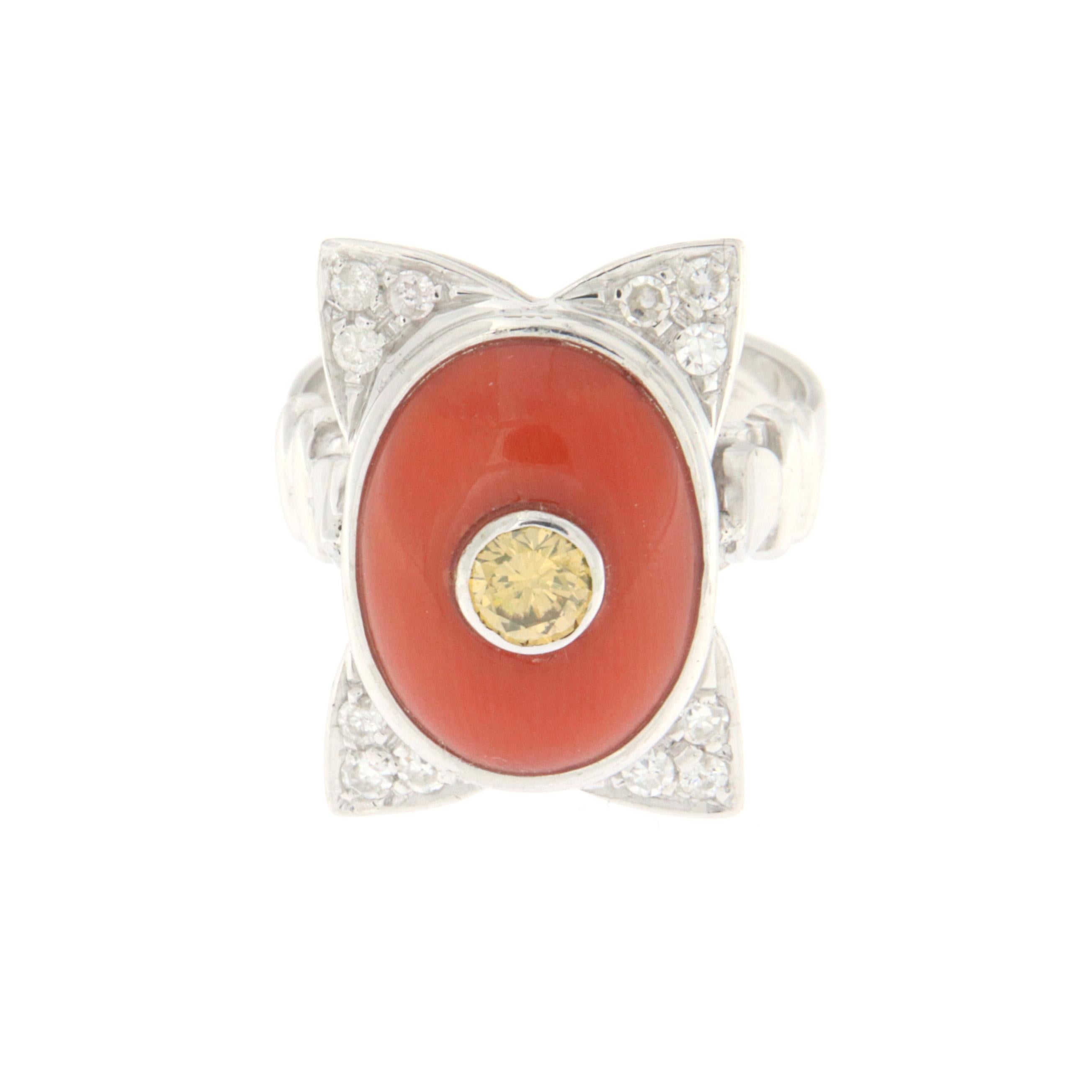 This exquisite 18-karat white gold ring is a masterpiece of design and luxury. At its center, it features an oval-cut natural coral of deep and enticing color, enclosing within it a 0.30-carat yellow diamond. This central gem, unique in its kind,