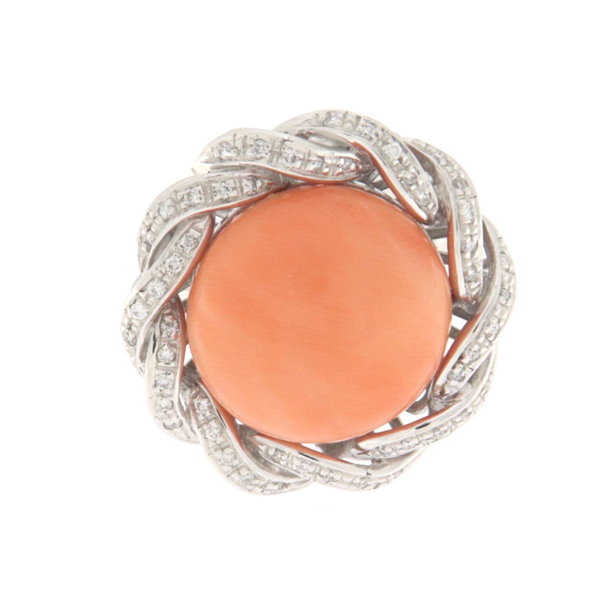 Dieser elegante Ring aus 18 Karat Weißgold verkörpert zeitgenössische Raffinesse, bereichert durch strahlende Diamanten, die eine natürliche Koralle in der Mitte meisterhaft einrahmen, die sorgfältig in eine runde, knopfähnliche Form geschnitten
