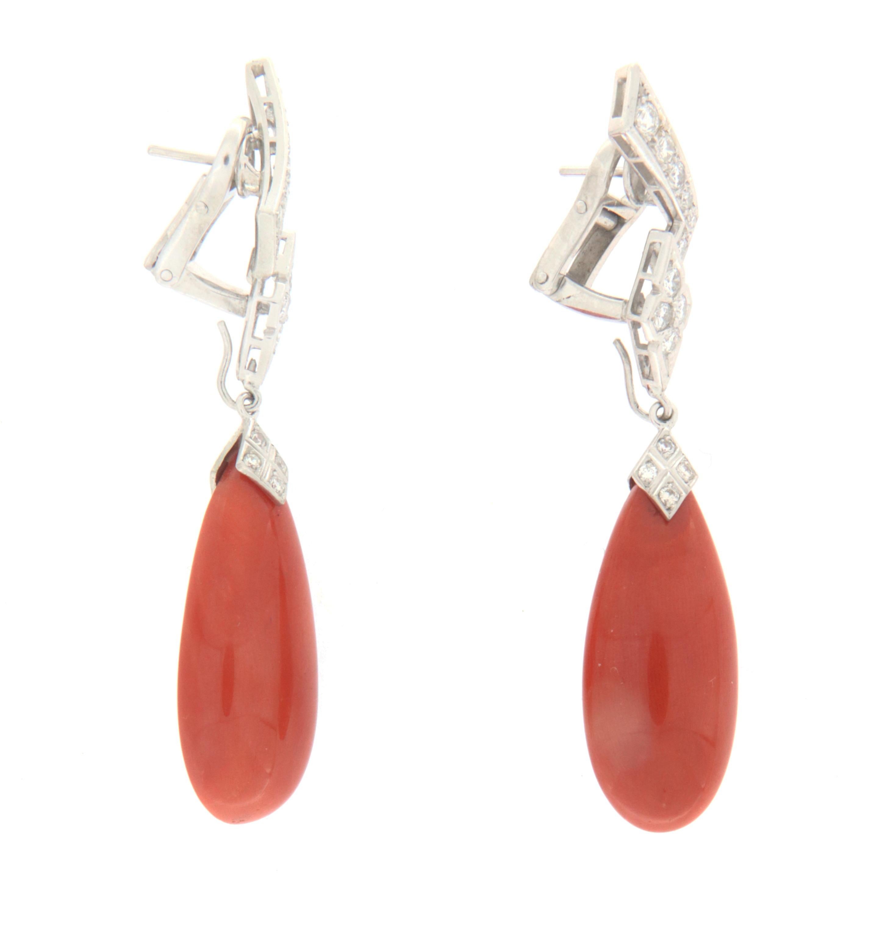 These exclusive earrings in 18-karat white gold represent a perfect blend of the sea's grace and sparkling luxury. At their heart, exquisite drops of red coral dangle elegantly, evoking the image of a sunset over the ocean. These natural gems,