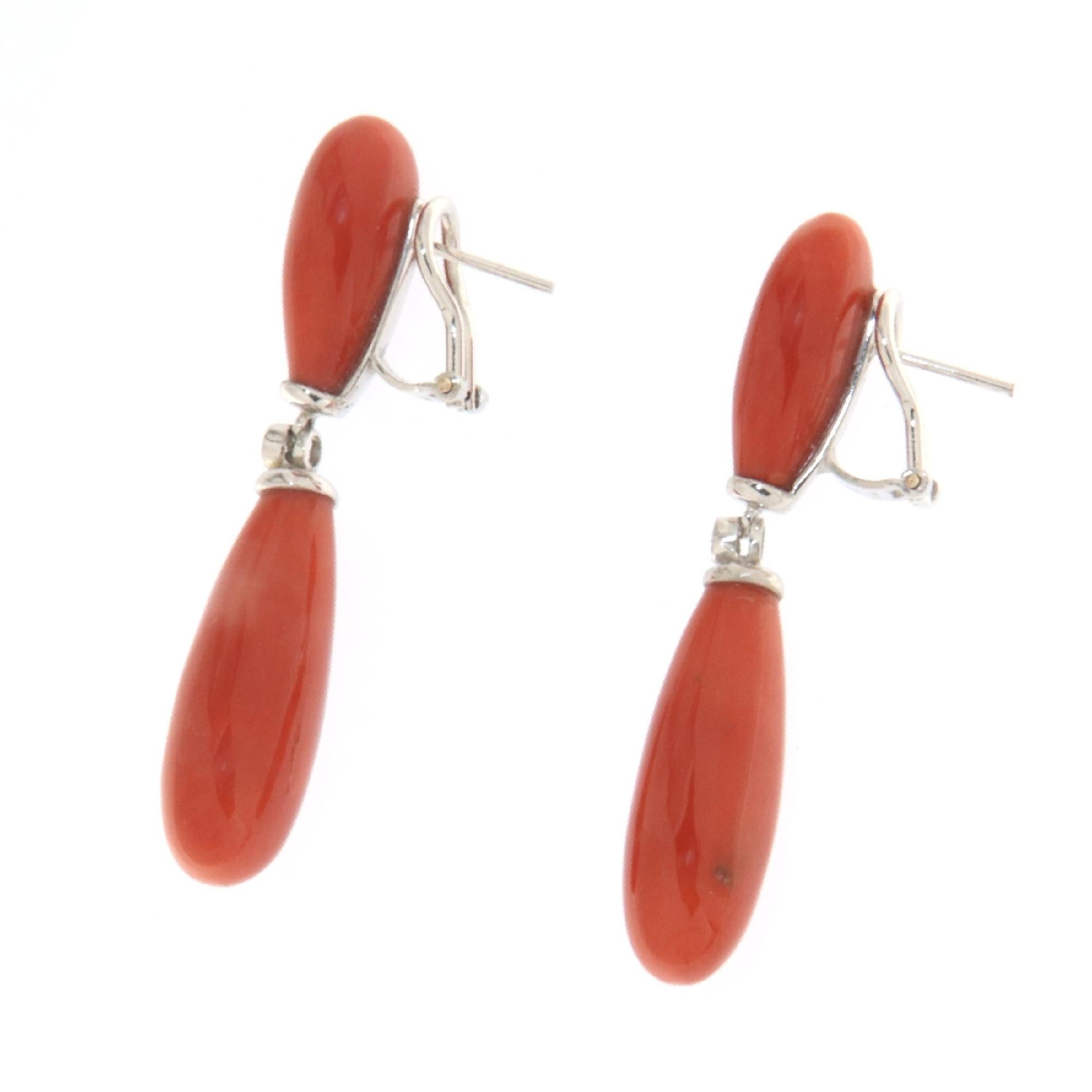 These elegant drop earrings in 18-karat white gold celebrate the mastery of Italian craftsmanship, representing a perfect symbiosis between modernity and tradition. The elongated shapes of the natural Sardinian coral, renowned for its deep red color