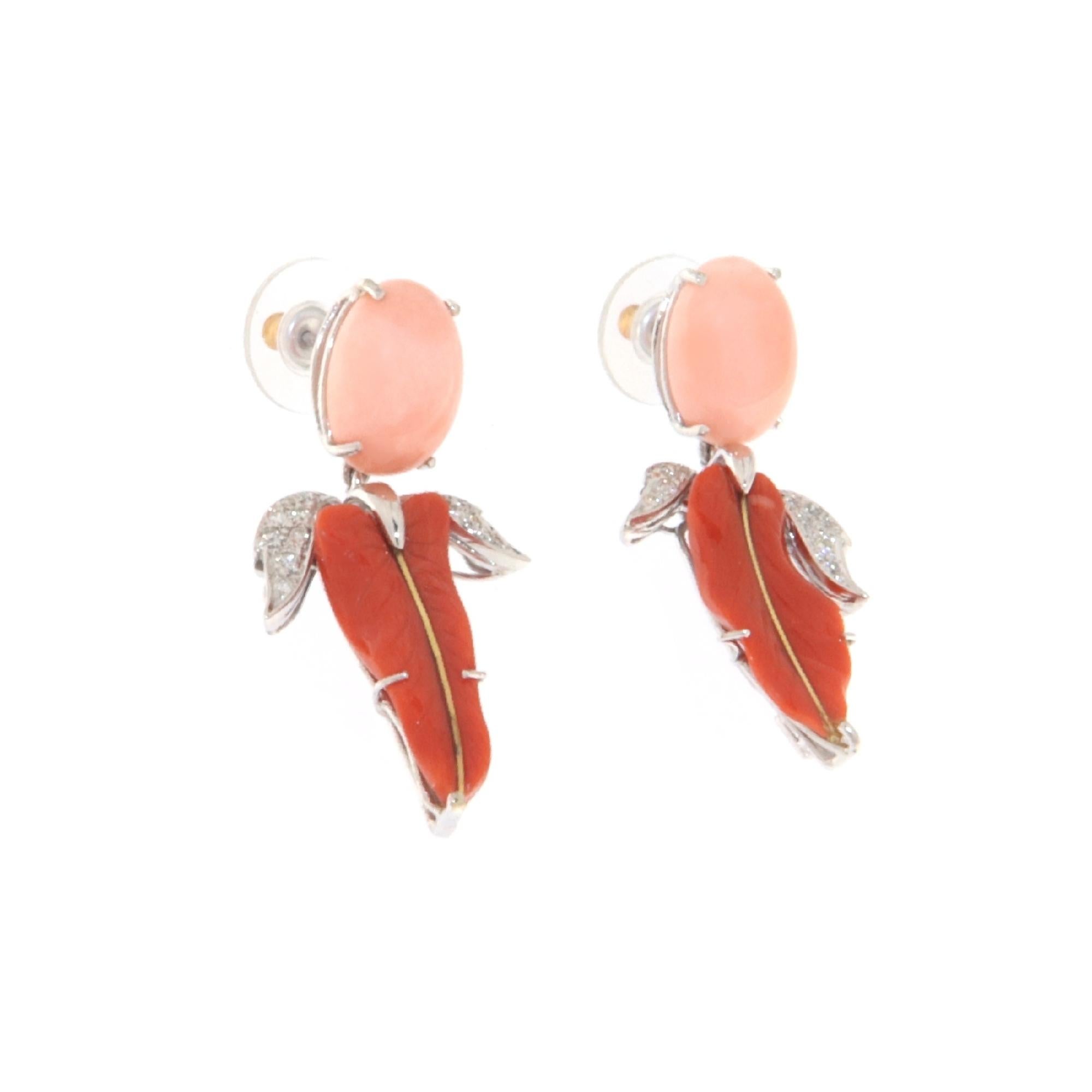 Spectacular pendant earring made in the eighties by expert Neapolitan craftsmen in 18 Karat white gold composed of two oval-shaped angel skin corals in the upper part that support two engraved red coral leaves surrounded by diamonds.
Silicone cap