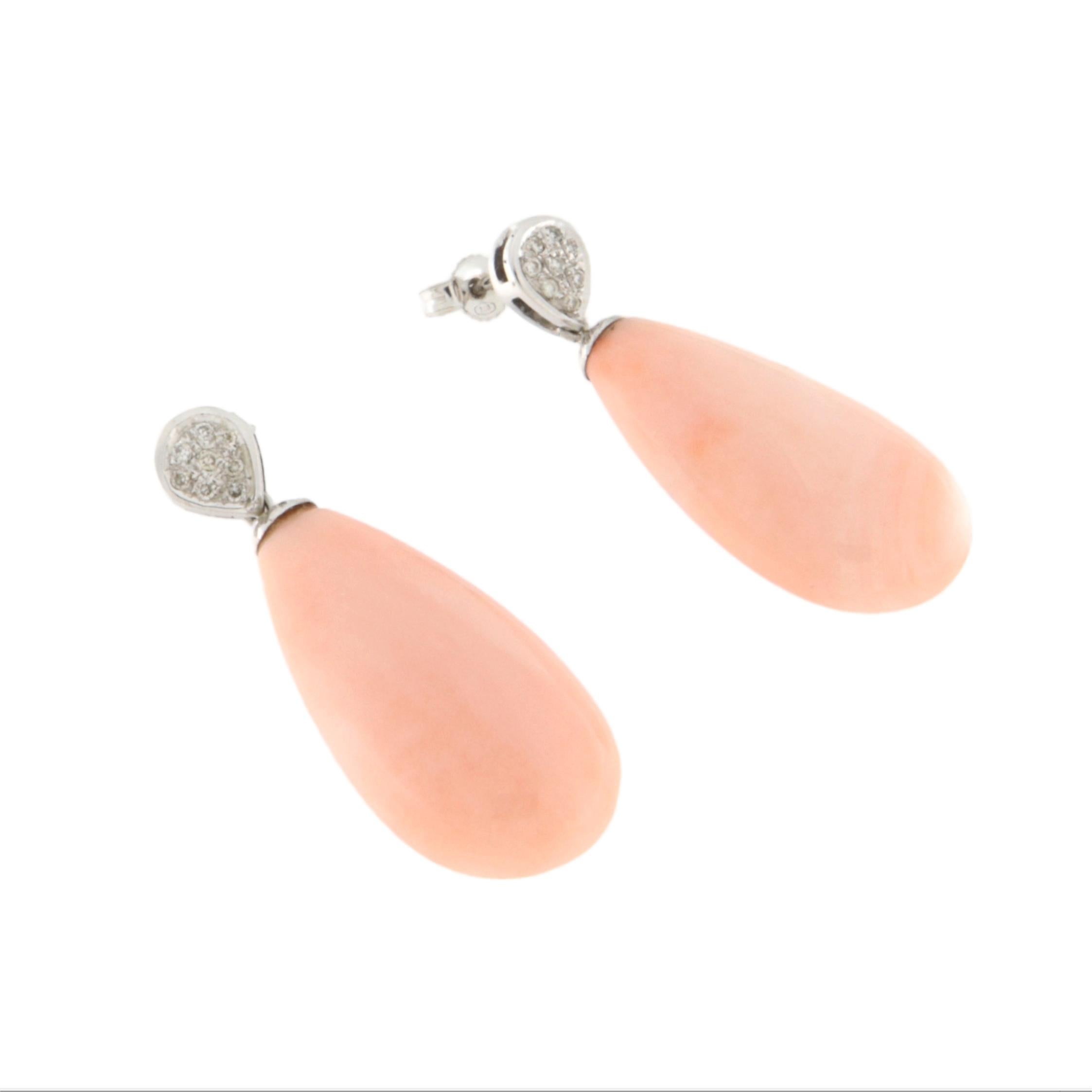 Délicates, raffinées et intemporelles, ces étonnantes boucles d'oreilles pendantes sont réalisées en or blanc 18 carats et serties de corail rose naturel et de diamants taille brillant. Leur design à la fois élégant et understated design les rend
