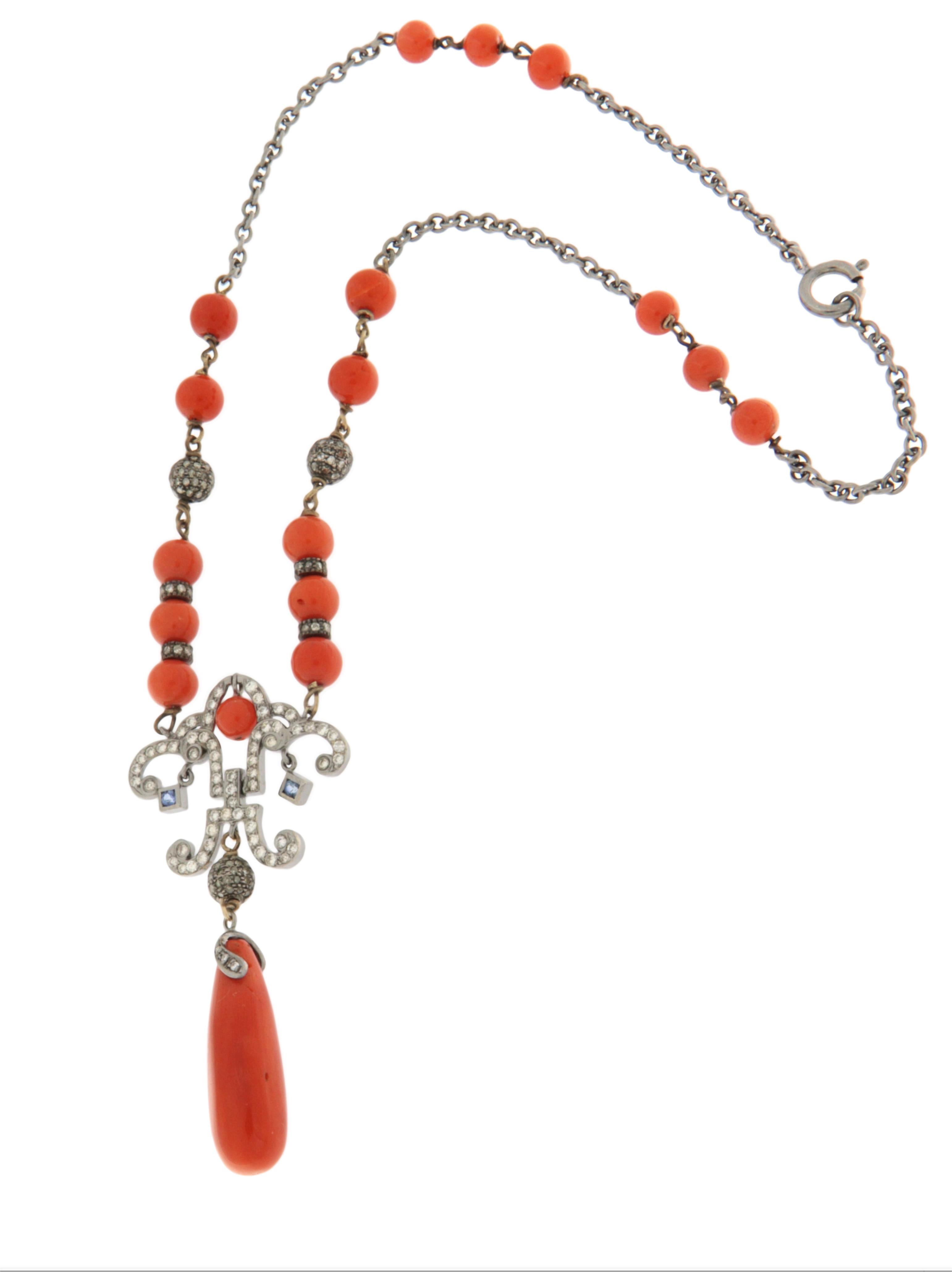 Una splendida collana antica risalente agli anni '50, un esempio di alta gioielleria italiana realizzata con materiali nobili e maestria artigianale. La collana è realizzata in oro bianco 18 carati, elegantemente abbinato a una selezione di corallo
