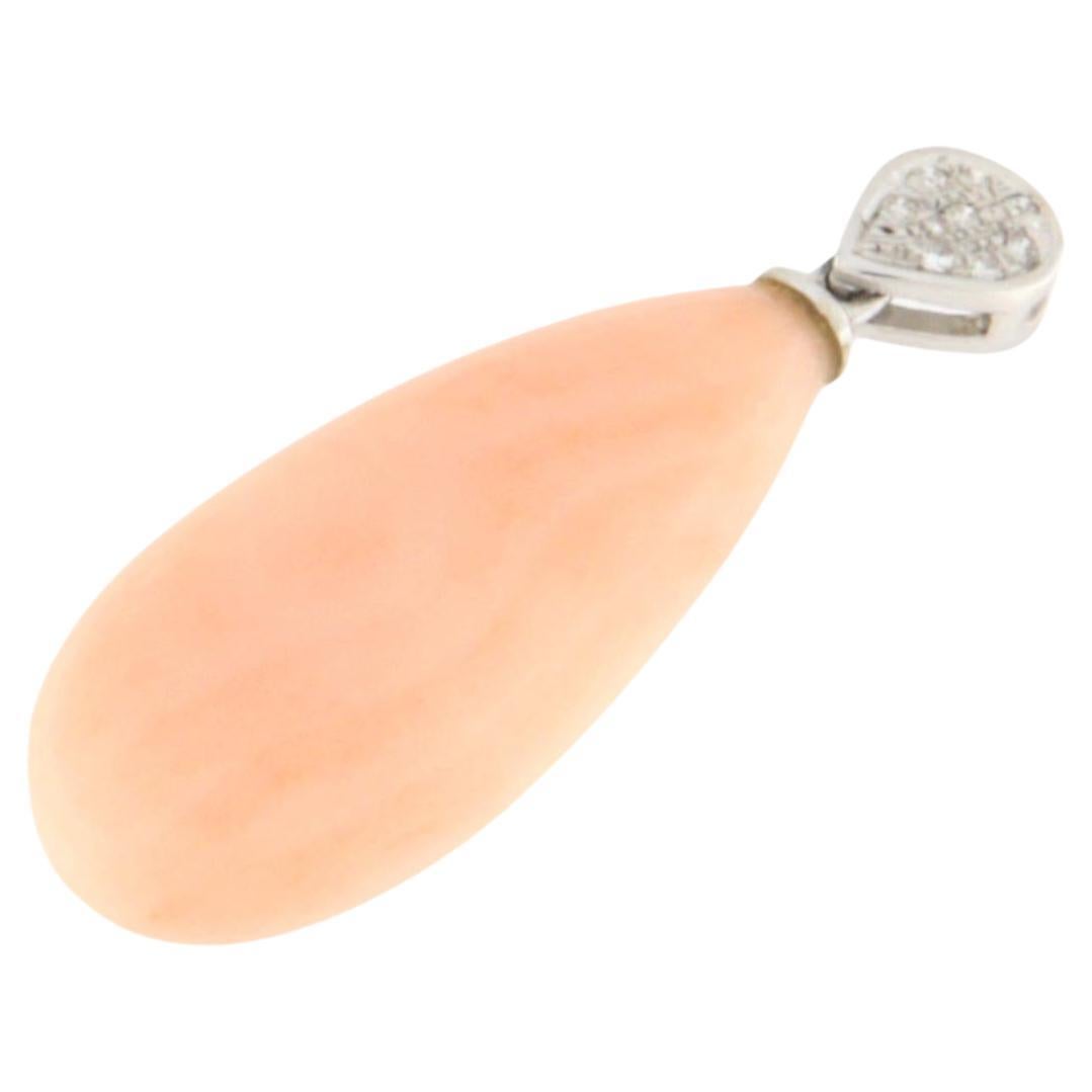 Elegant 18-karat white gold pendant, adorned with a stunning drop-shaped natural pink coral and a pavé of brilliant-cut diamonds, meticulously set in a teardrop-shaped mount. This piece is a refined expression of style and sophistication, where the