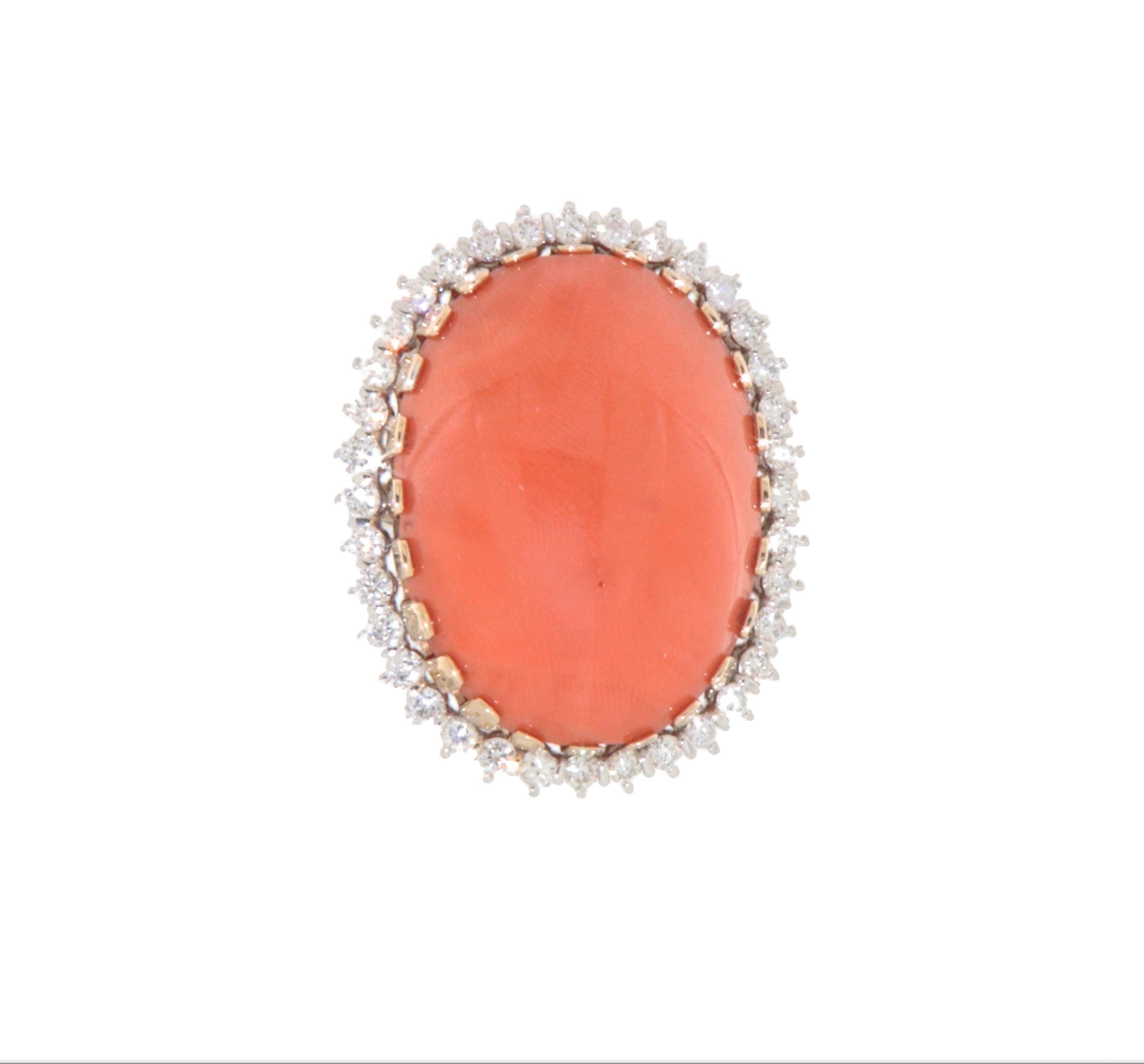 This magnificent ring in 18K yellow and white gold is a timeless example of elegance, crafted with extraordinary artisanal care. The design of this jewel is made unique by its central natural coral, which features a delicate orange hue, symbolizing
