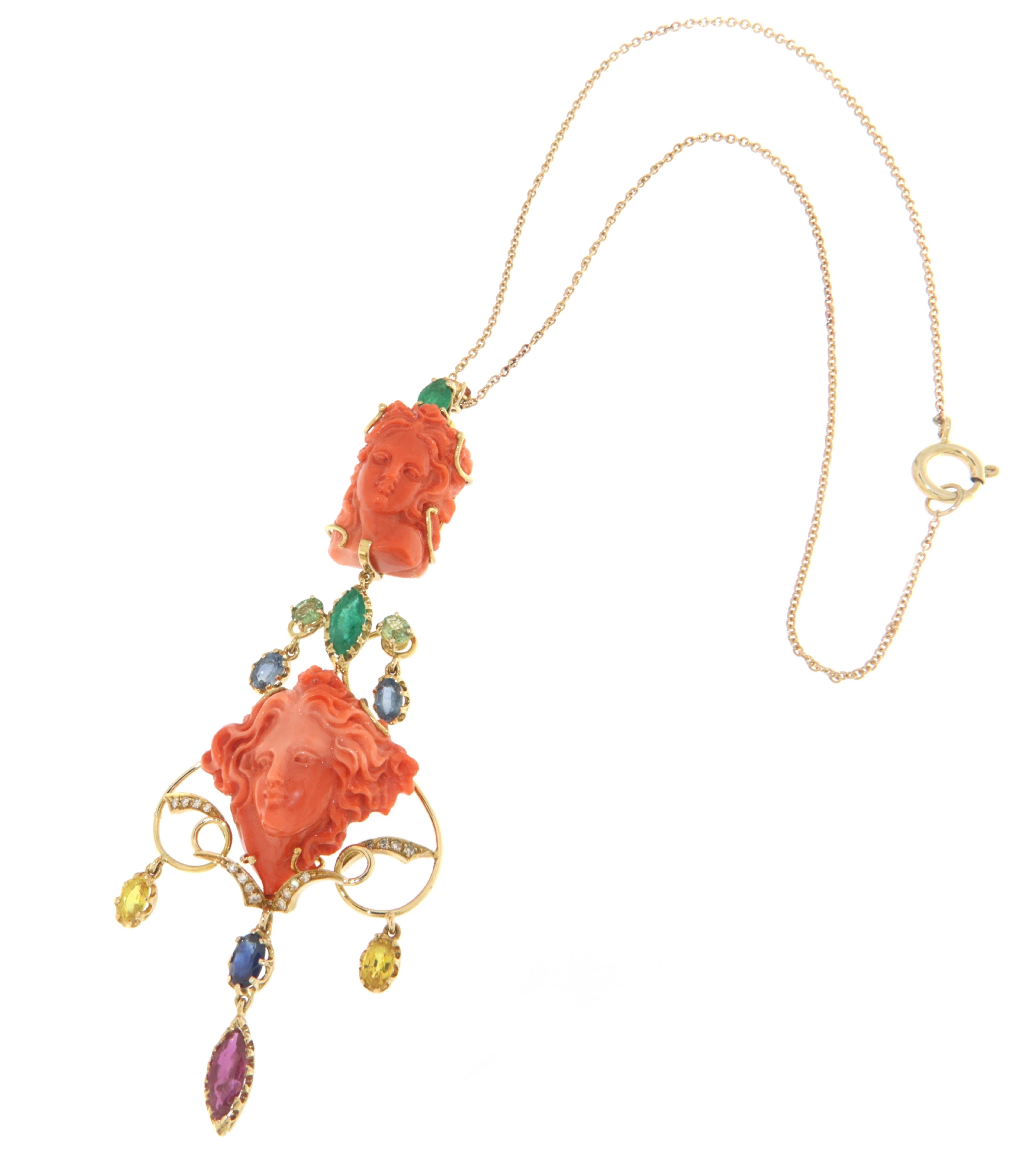 Spectacular pendant necklace made of 14K yellow gold, with an engraved coral face of a woman supporting a structure made up of gold ornaments and colored stones that surround another woman's face in engraved coral.

The textures of the colors and