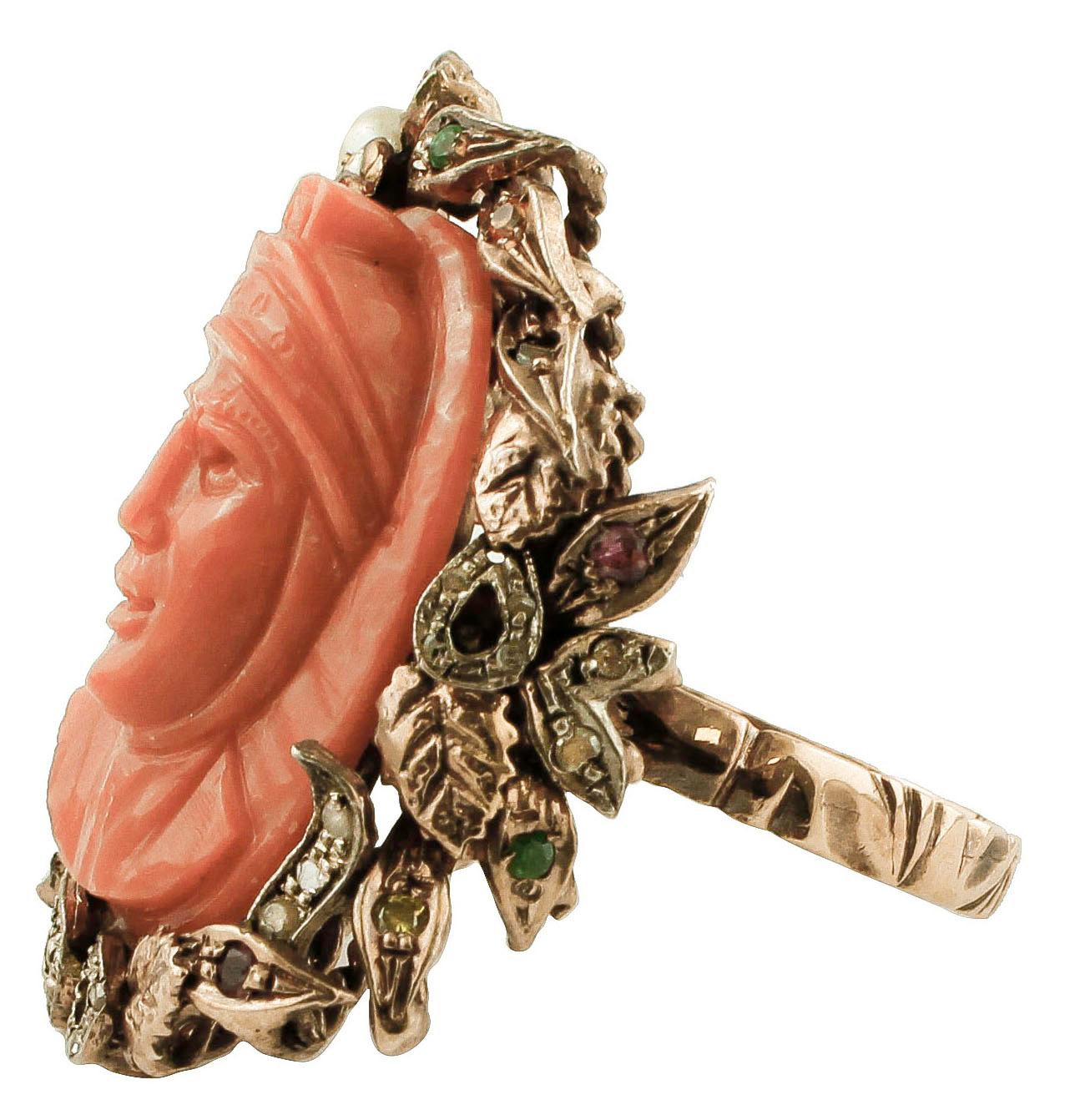Marvelous retro ring in 9k rose gold and silver structure mounted with a central finely carved elatius coral representing a beautiful woman profile, surrounded by  flower and leaves made of rose gold and silver studded with diamonds, rubies,