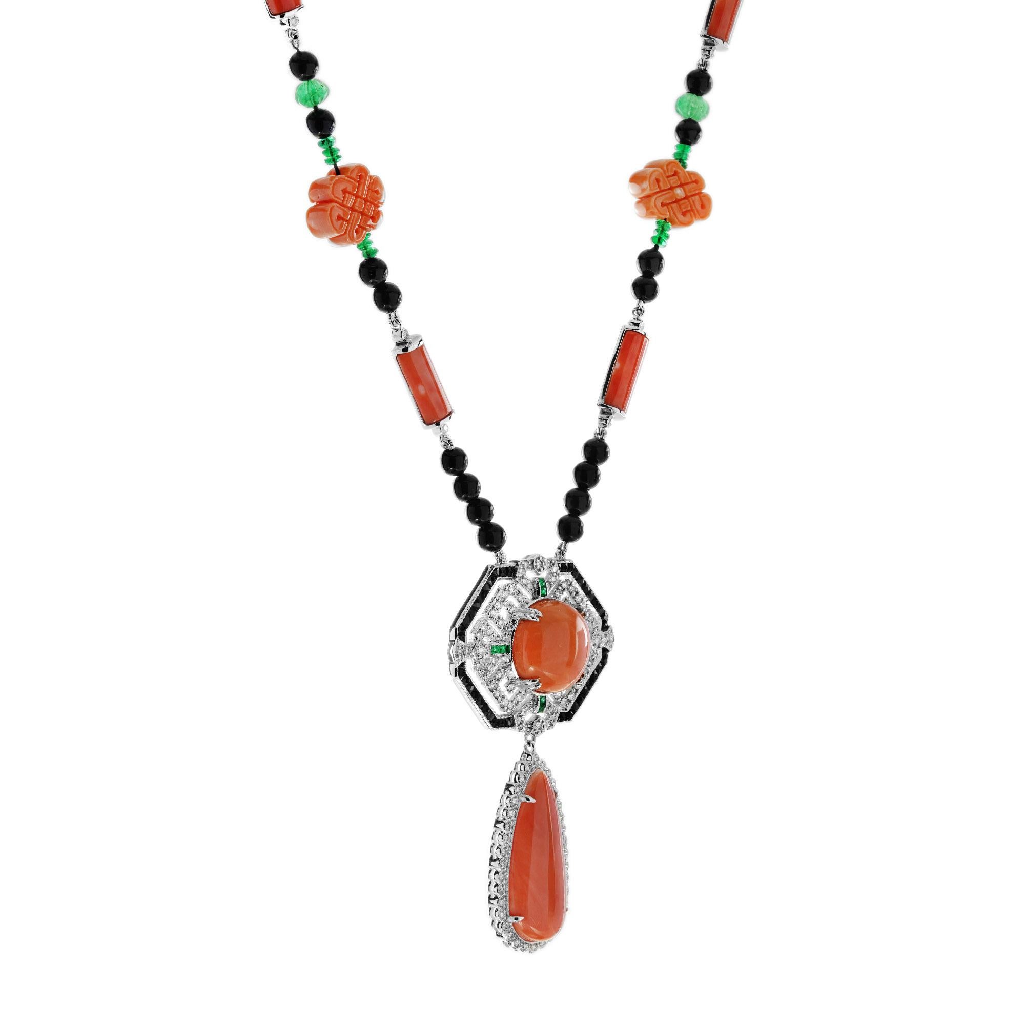 Mostra una gemma centrale rotonda di corallo, circondata da quattro smeraldi triangolari vibranti posizionati in alto, a sinistra, a destra e in basso. Il design è splendidamente incorniciato da diamanti brillanti, mentre l'onice a taglio francese