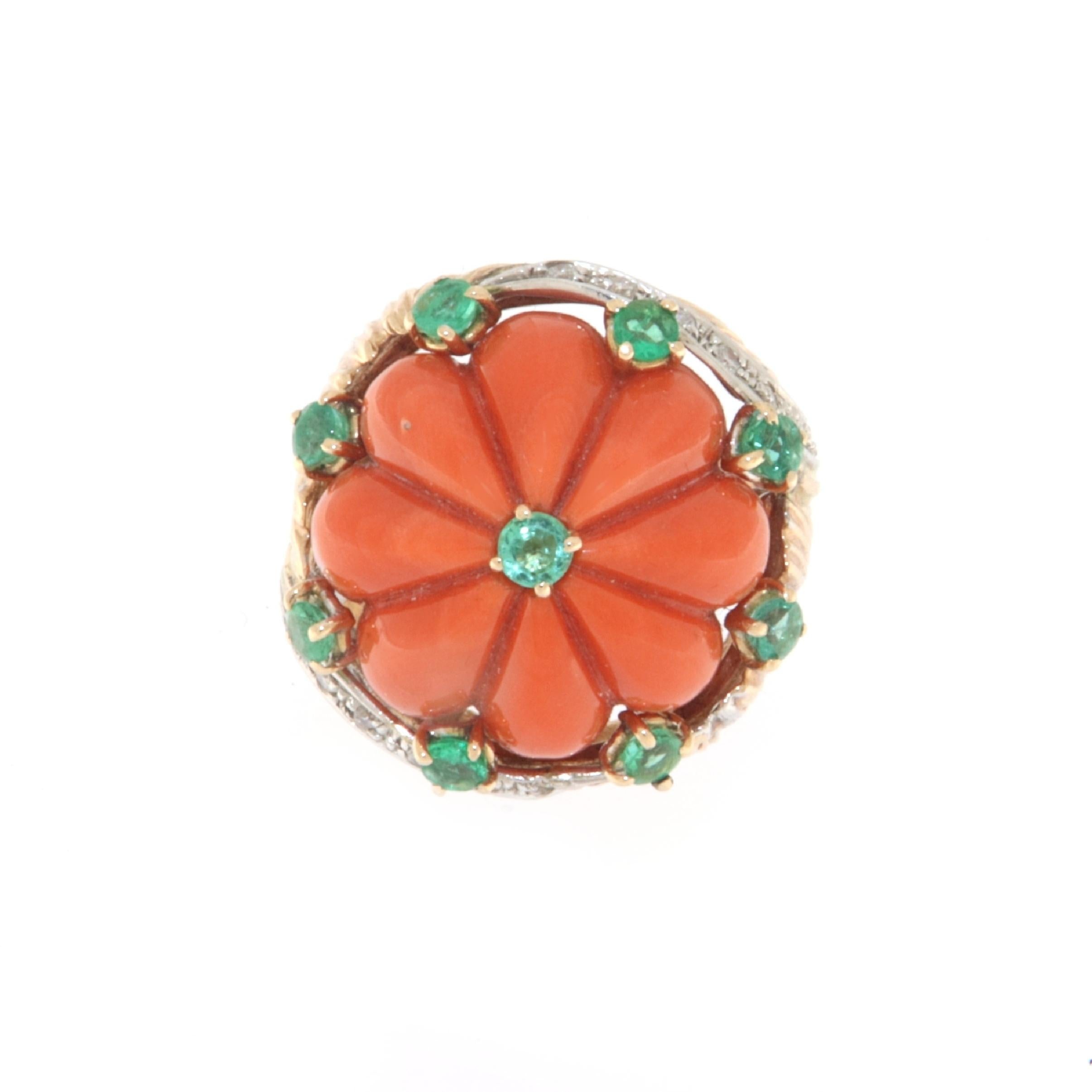 This captivating ring, crafted in a harmonious blend of 14-karat white and yellow gold, is a celebration of creativity and color. At its center, a coral of intense orange color takes a commanding presence, symbolizing joy and vital energy. The