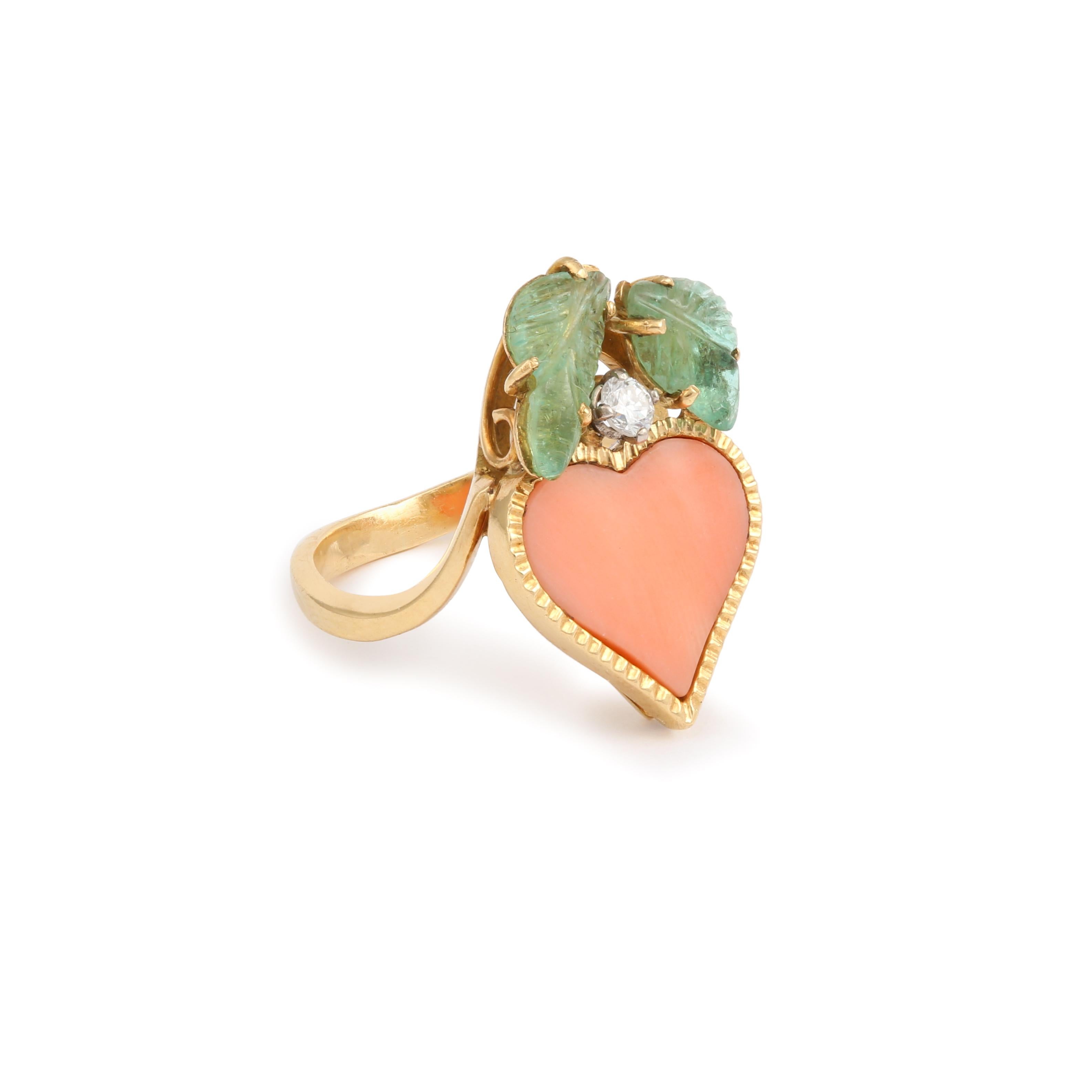 Charming yellow gold heart ring set with a heart-shaped coral topped with emerald leaf cabochons and a diamond.

Total estimated weight of emeralds: 1.60 carats

Estimated diamond weight: 0.08 carats

Dimensions: 22.18 x 14.48 x 5.16 mm (0.873 x