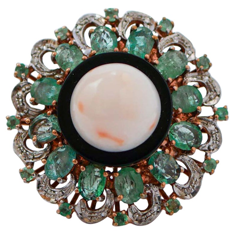 Anello in corallo, smeraldi, diamanti, onice, oro rosa e argento.