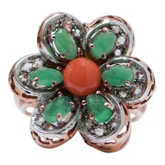 Anillo con forma de flor de coral, esmeraldas, diamantes, oro rosa y plata.