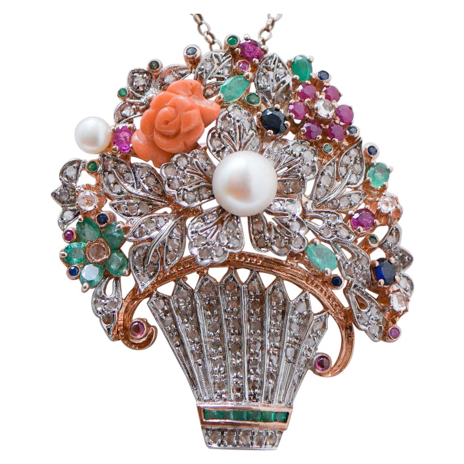 Corallo, smeraldi, zaffiri, rubini, diamanti, perle, ciondolo in oro e argento.