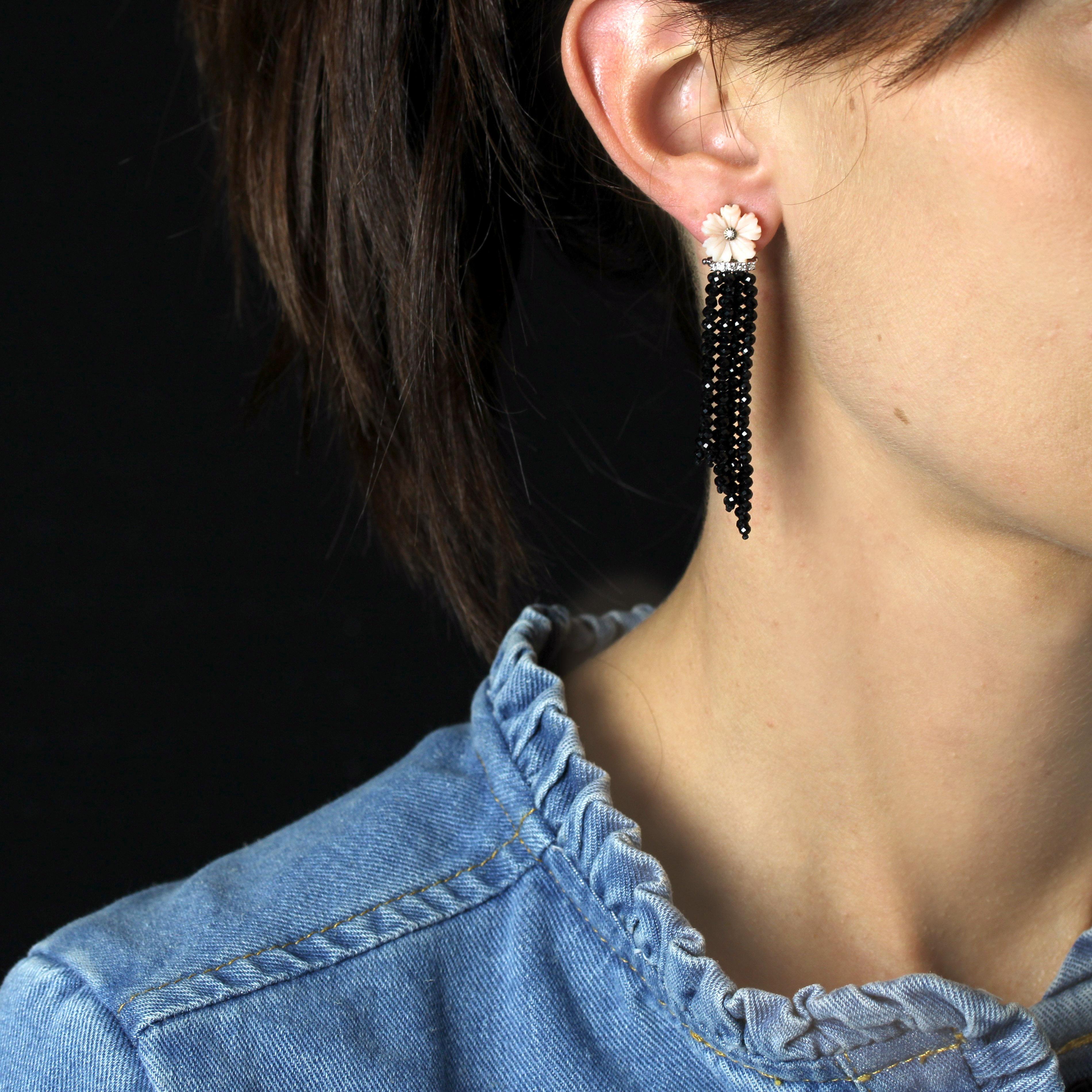 Para orejas perforadas.
Pendientes de oro blanco de 18 quilates.
Estos femeninos pendientes en forma de gota presentan una flor de coral piel de ángel, centrada con un pequeño diamante talla brillante moderno en engaste ilusión, rodeada por una