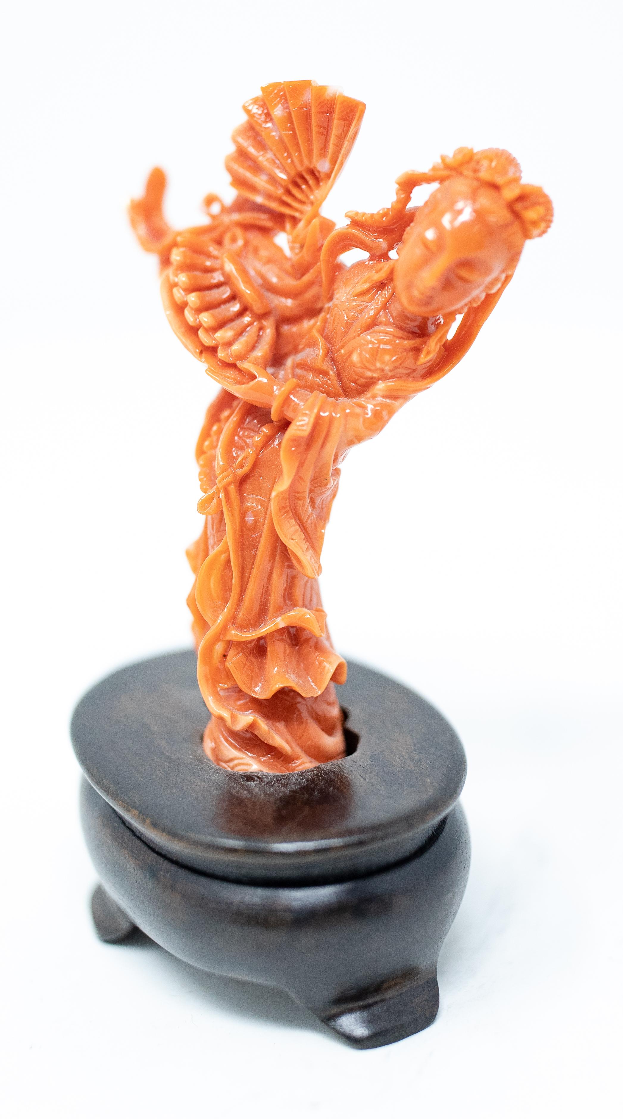 Offering this stunning hand carved Coral figure of a Geisha on a wooden base. The coral is very vibrant and the carving it absolutely stunning. This coral is intricate, and the geisha has beautiful flowing gowns and ropes as her dress. She is