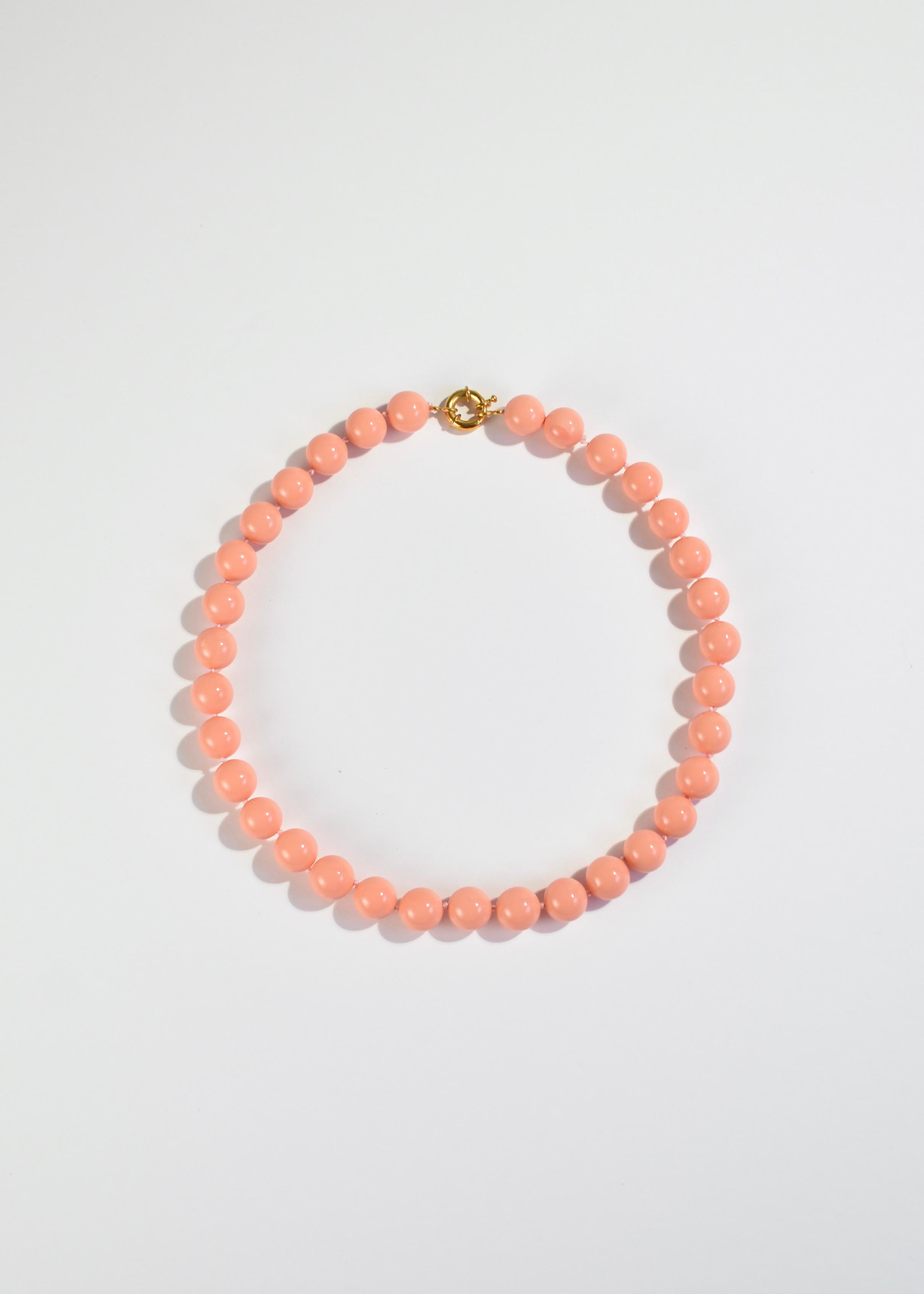 Stunning vintage necklace with round coral glass beads and an oversized clasp closure.

Material: Gold vermeil, glass. 