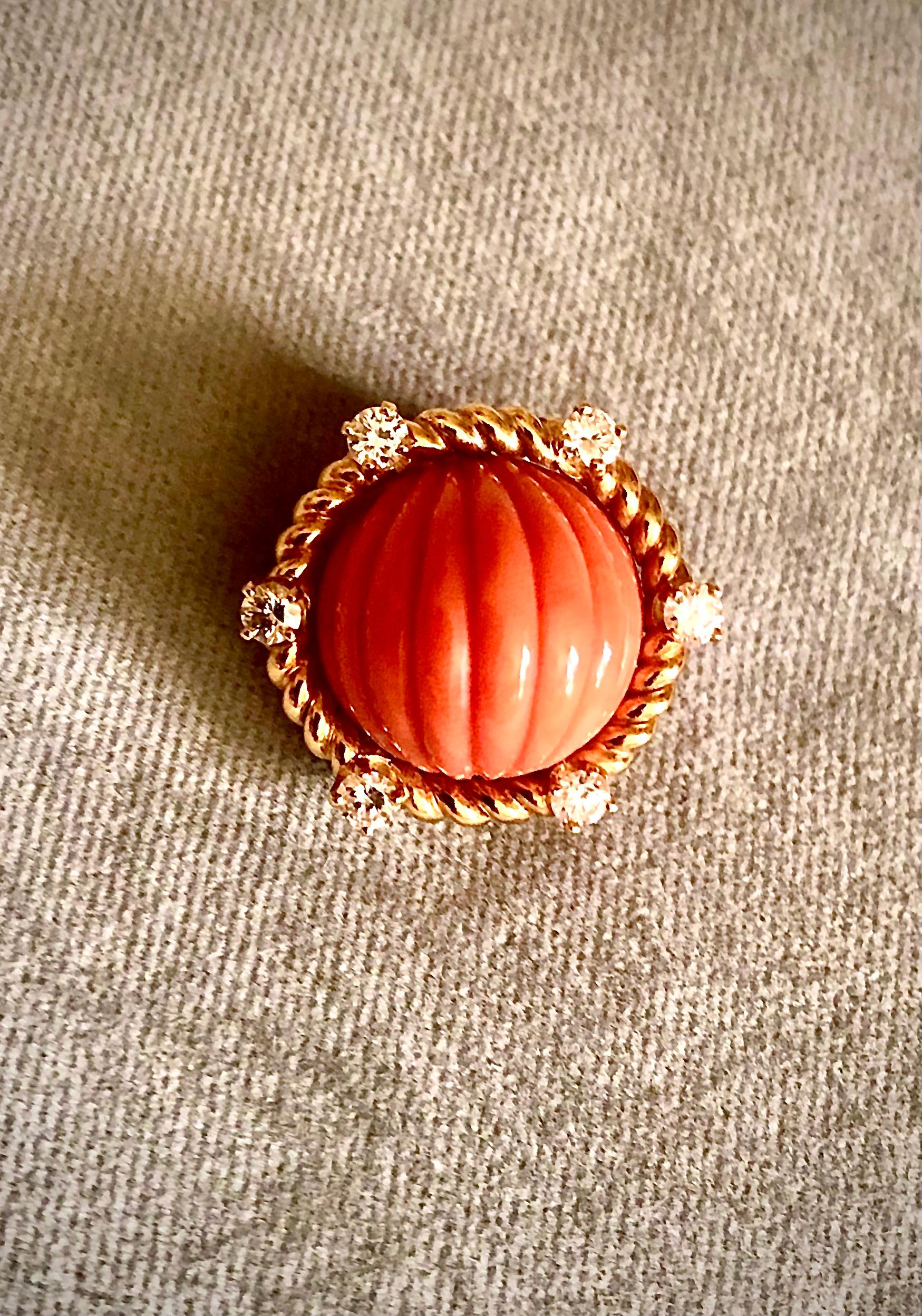 Simple but extremely elegant earrings. Main stone is carved fluted Sciacca Mediterranean coral of a warm lush orange tonality. Very well carved, of even color throughout and well matched.

The gems are set within a rope twisted 18kt gold halo. This