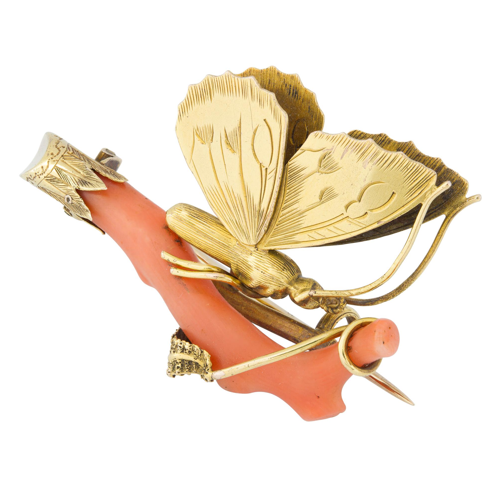 A late nineteenth century gold and coral brooch, the coral branch with patterned gold foliate design to tip, supporting a yellow gold butterfly with engraved wing and body, measuring approximately 4cm x 2.6cm, circa 1890, gross weight 5.4