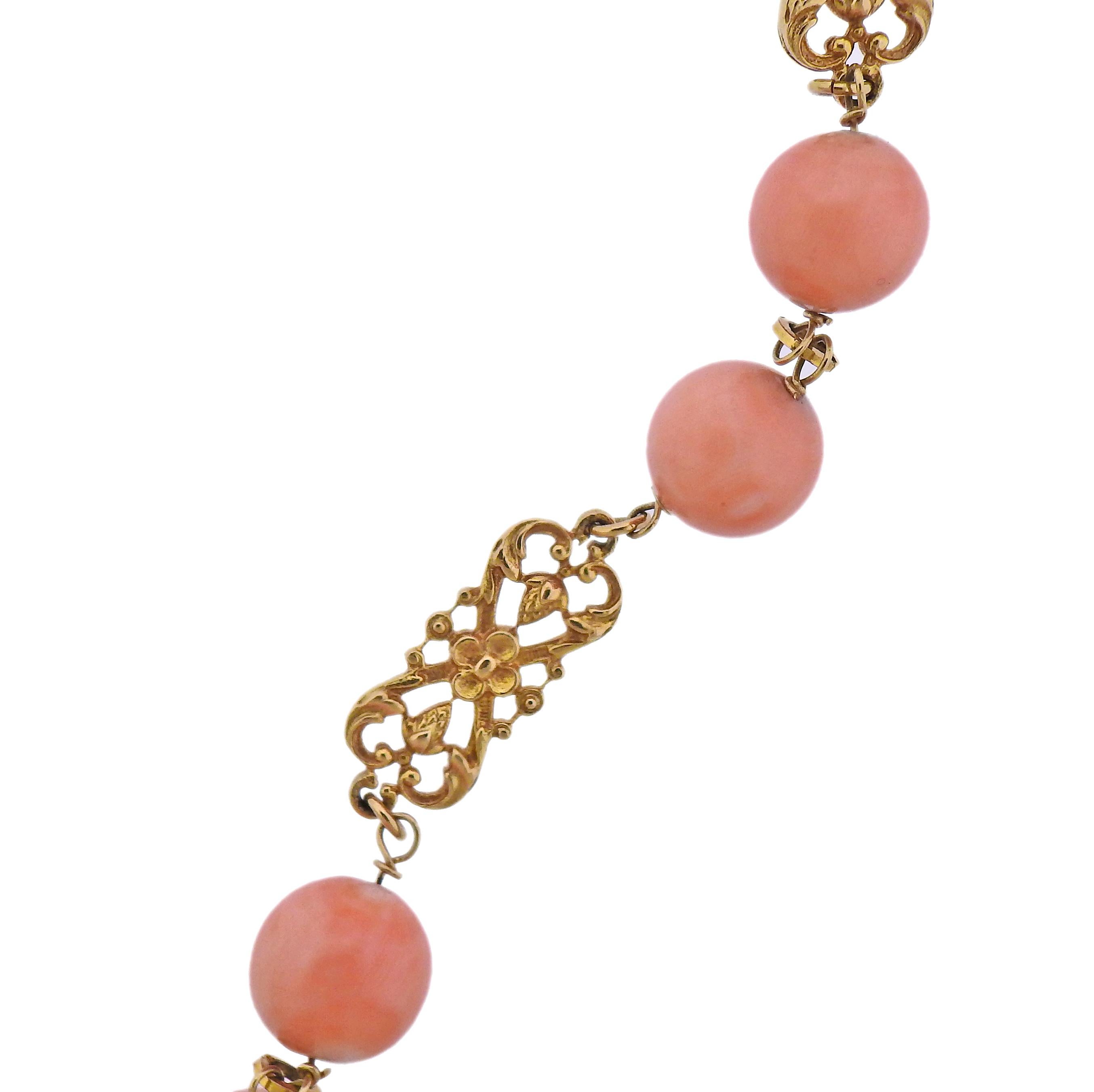 14k gold long necklace with coral beads, measuring from 9.7mm to 15.4mm. Necklace is 33