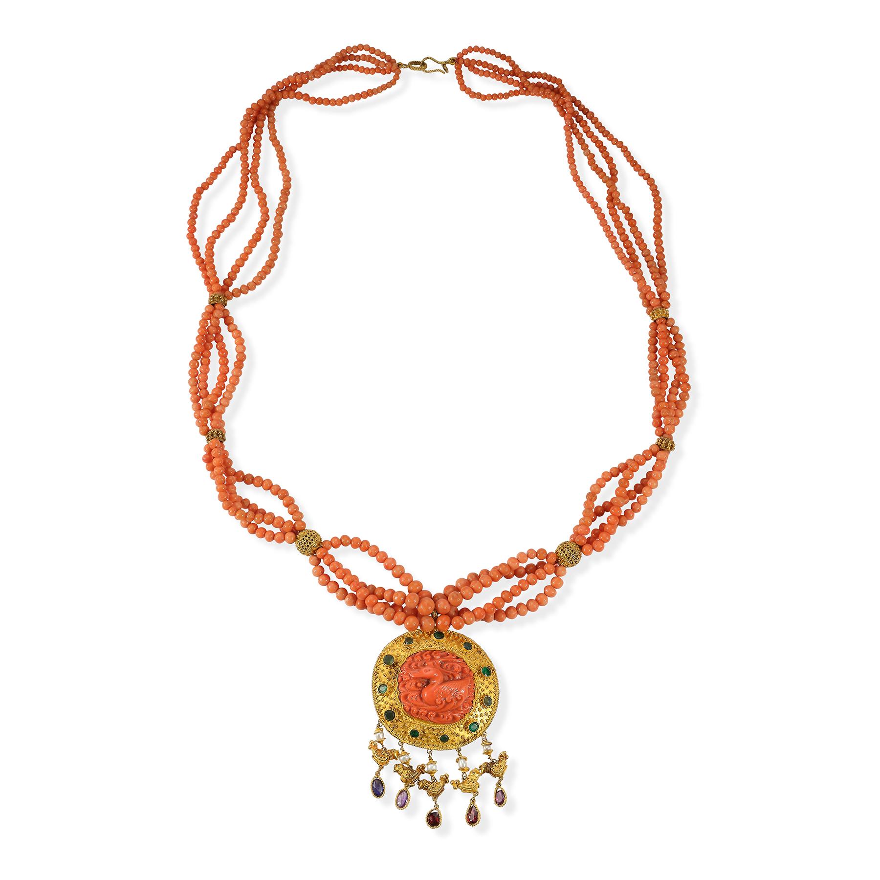 Coral & Gold Multi Strand Fish Pendant Necklace 

4 strands of coral beads connected by gold spacers set with a carved coral fish pendant set with emeralds and garnets and gold birds.

Measurements: 32