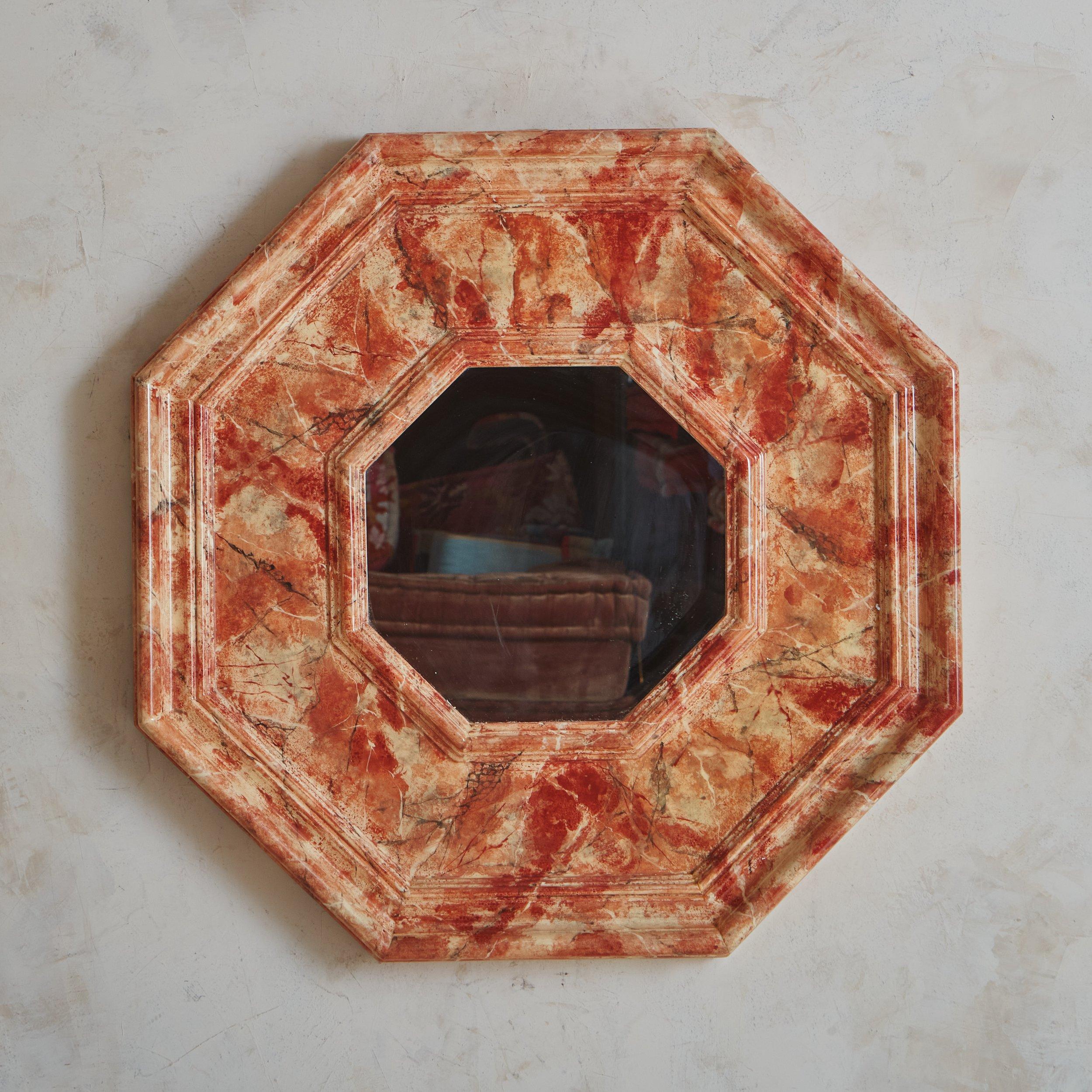 A 1960s Italian wall mirror featuring a hexagonal wood frame with a beautiful lacquered faux marble finish in a range of coral, taupe and black hues. Unmarked. Sourced in Italy, 1960s.
 

 DIMENSIONS: 31