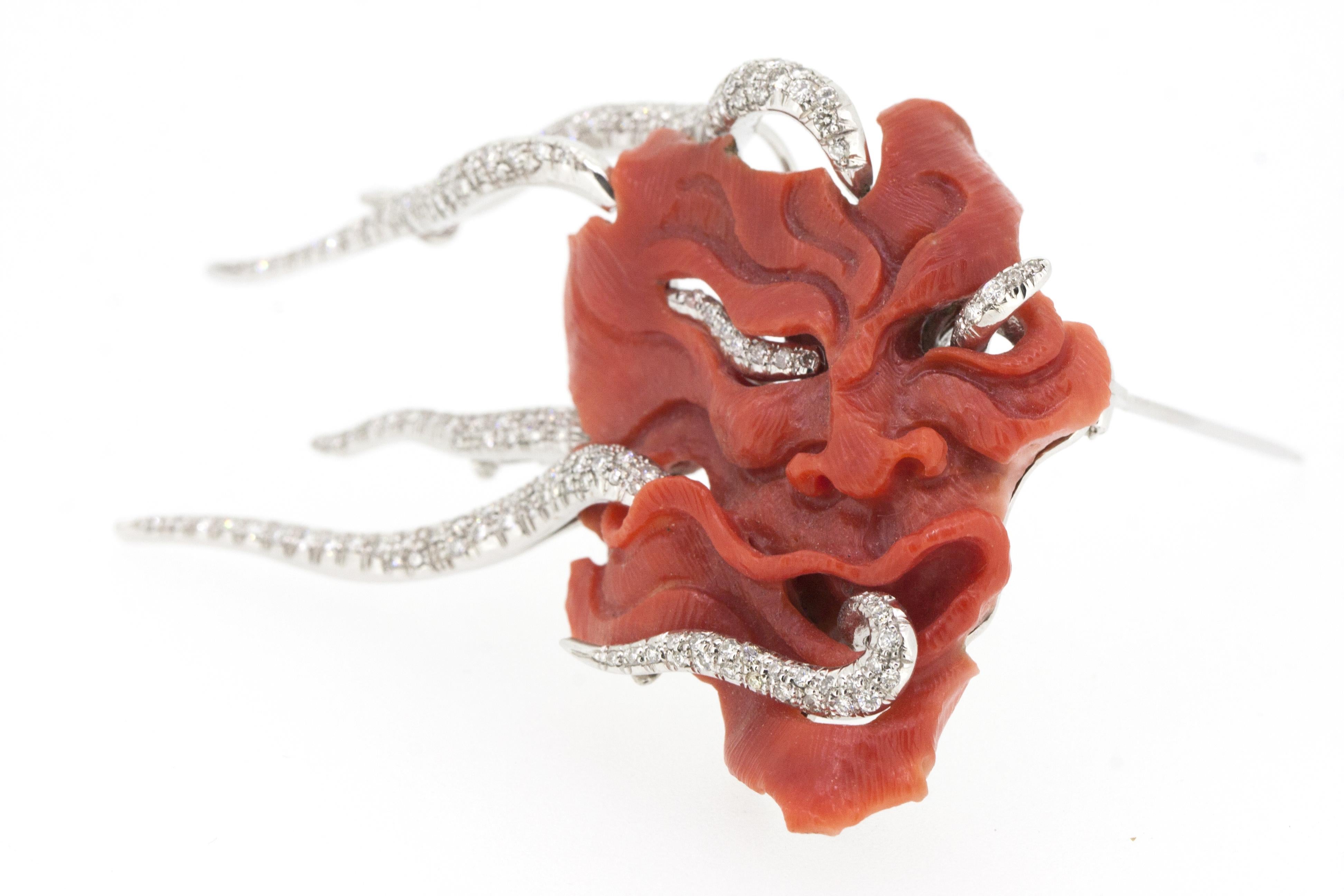 The coral mask brooch is a unique piece handcrafted in Italy by Generoso di Sieno. 
The piece weight 20.50 grams of white 18k gold and 9 gram of coral and displays 1.30 ct of white diamonds. 
The coral mask is the masterpiece of the artisan coming