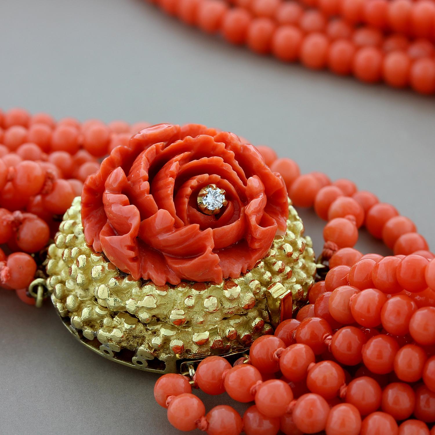 A sophisticated coral necklace accentuated by a coral rosette with a single round cut diamond set in the center. The coral rose sits on a 18K yellow gold mounting which complements the rich red color of the coral. The seamless box clasp ensures for