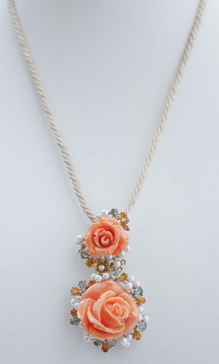 Amazing pendant in 14 kt white gold structure mounted with two flowers of coral surrounded by diamonds, multicolor sapphires and little pearls. The pendant will come with a rubber chain.
This pendant was totally handmade by Italian master goldsmiths