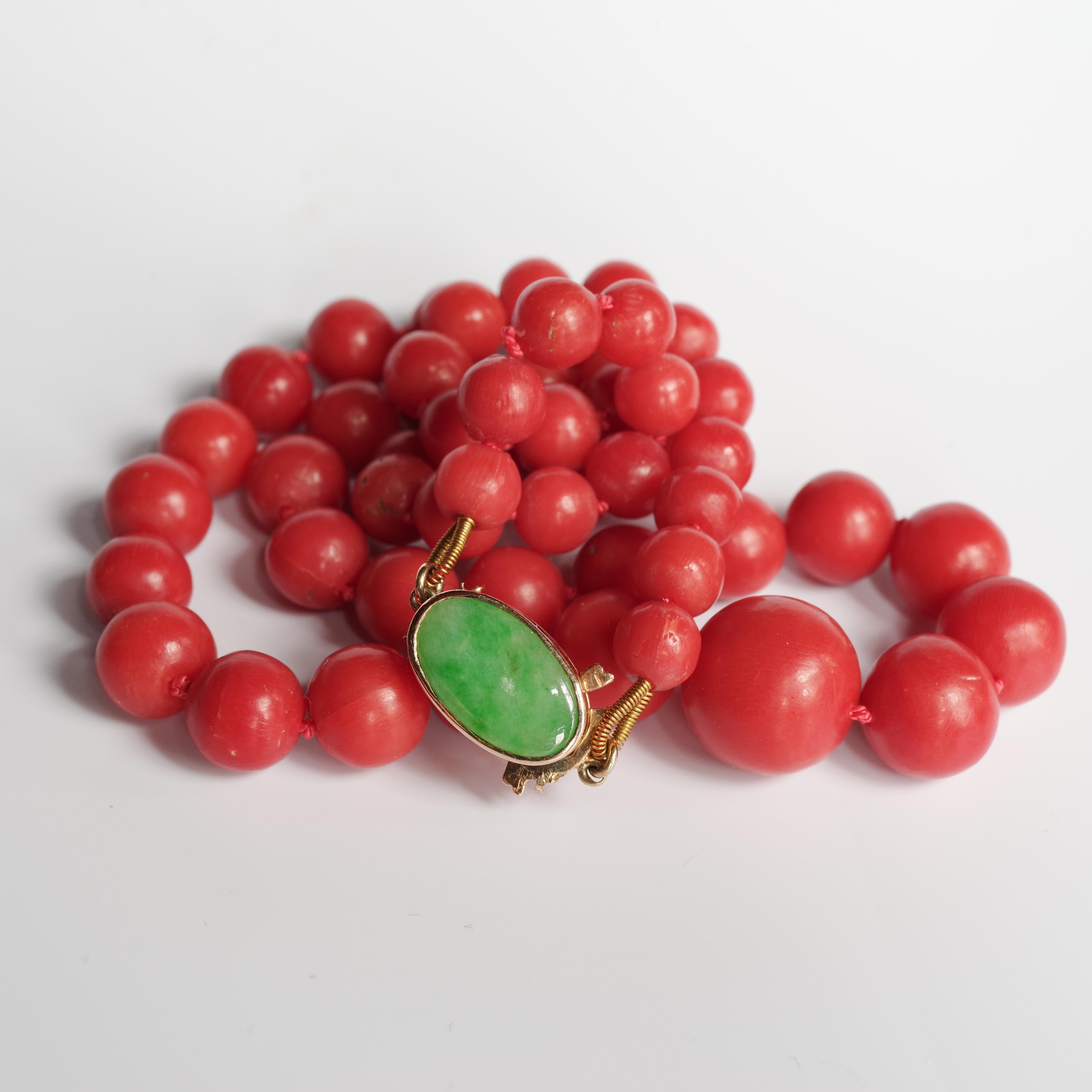 This fine precious coral necklace is composed of 55 hand-carved and polished natural undyed tomato-red coral beads that are graduated in size from 6.38 mm to 13.30 mm, which is ideal for an 18