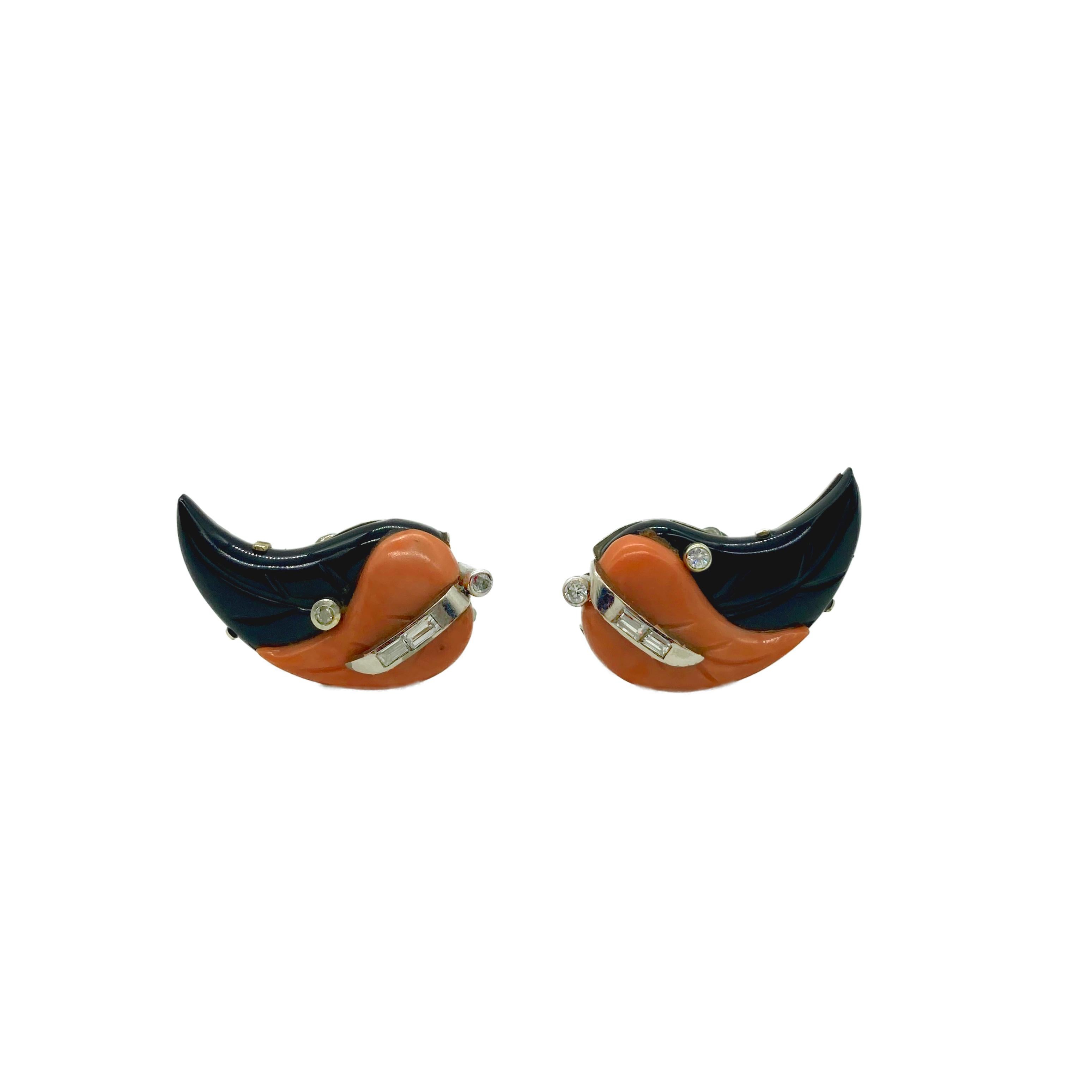 A stylish pair of earclips featuring coral and onyx, and accented with diamonds. Circa 1960s.