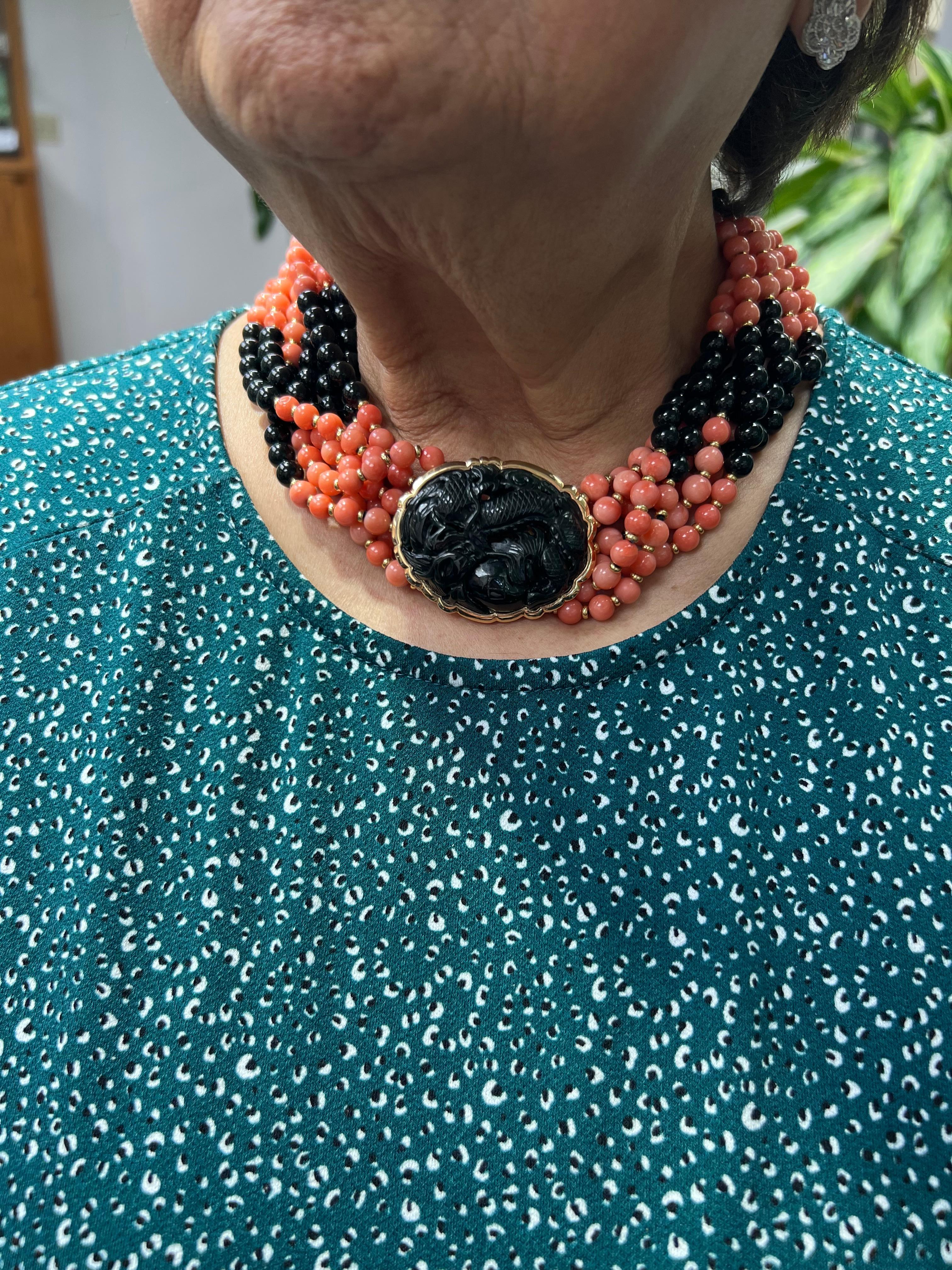 1970s Coral Onyx Black Jade Multi Strand Torsade Bead Necklace.

The 1970s Coral Onyx and Black Jade multi-strand torsade bead necklace is a work of art.  The large clasp is set with a carved Black Jade image of a dragon.  And spaced between the 