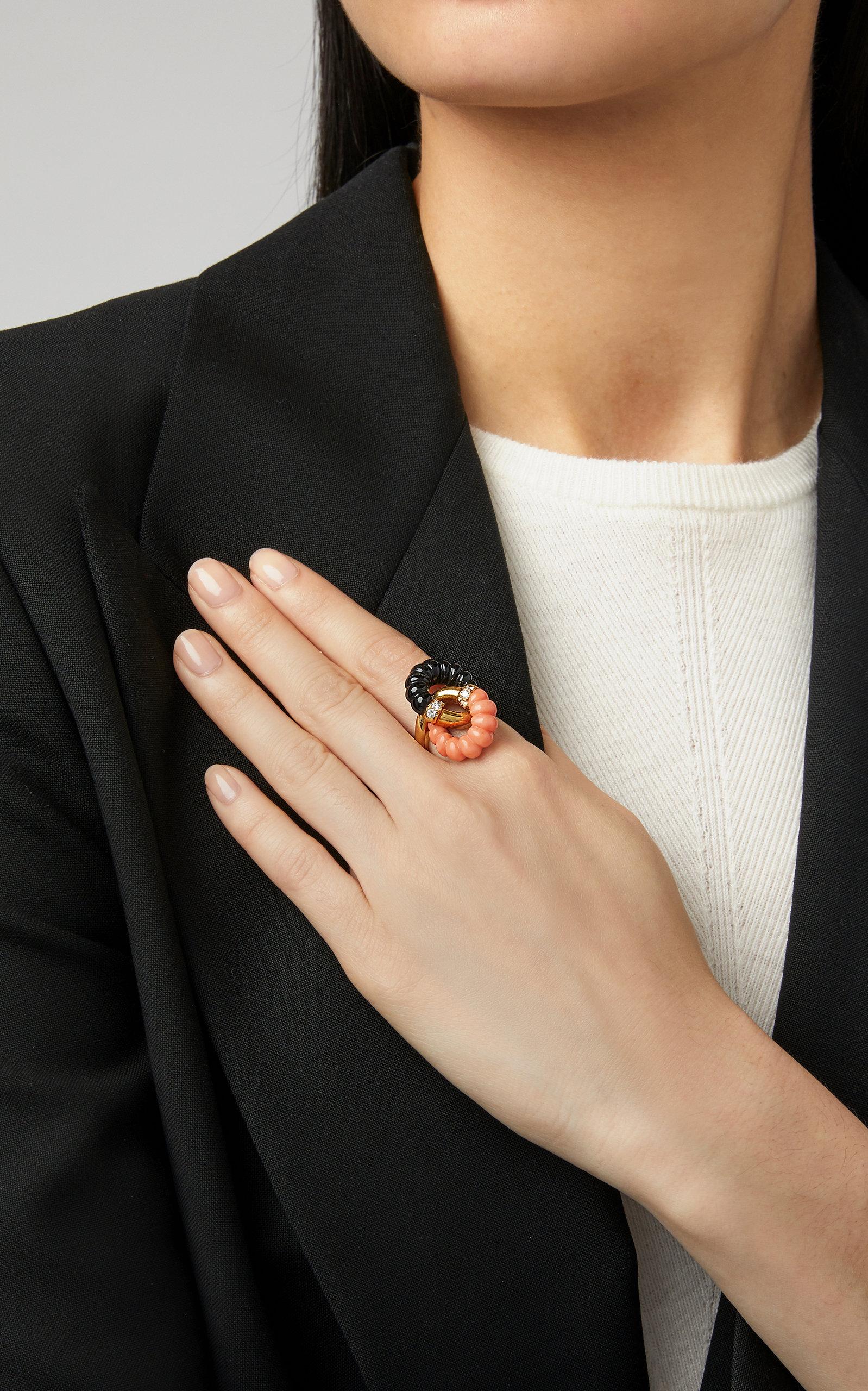 A chic ring in 18kt yellow gold with undulating coral and black onyx, and round diamonds. Made in France, circa 1968.