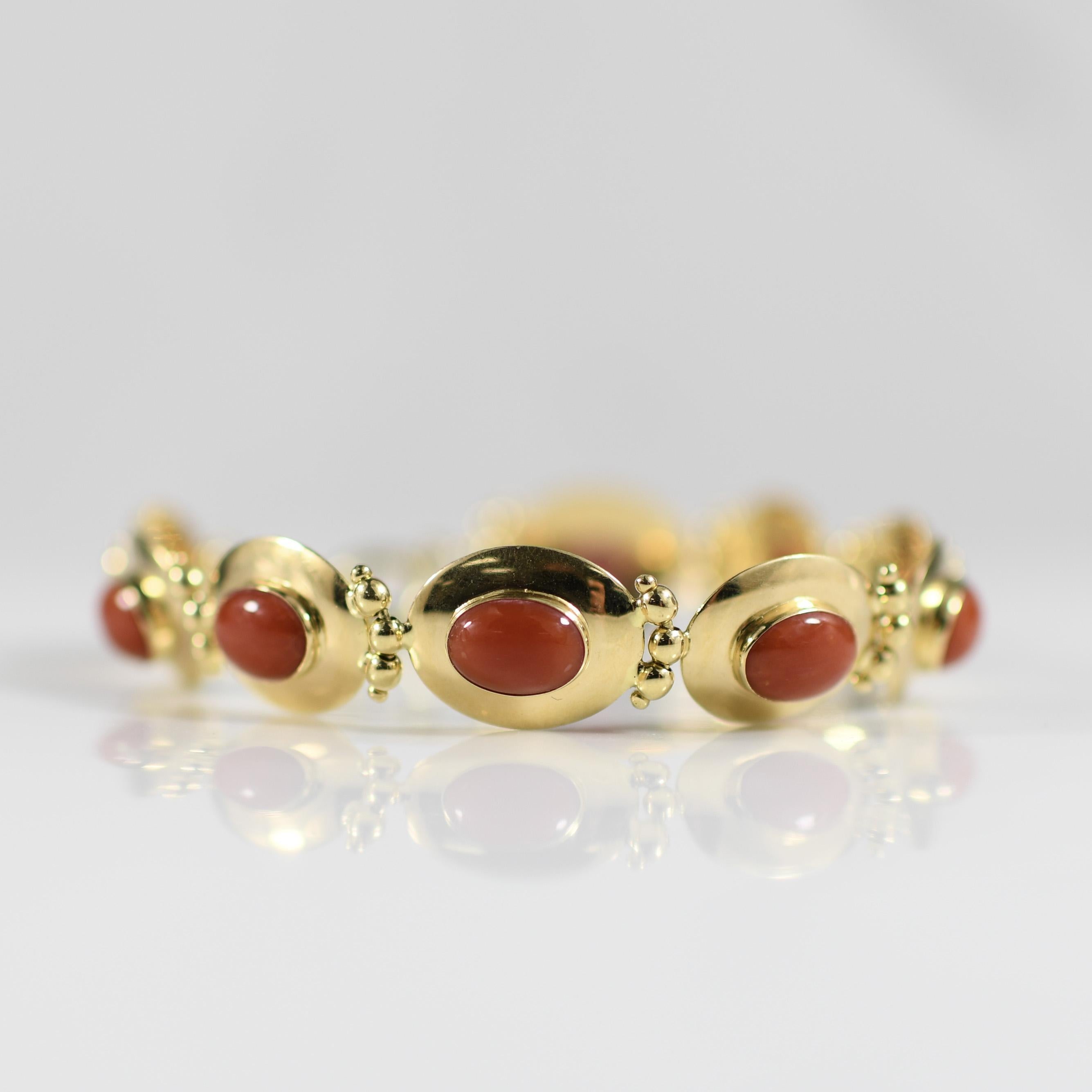 Adorn your wrist with timeless elegance in the form of this exquisite 18k yellow gold bracelet featuring coral oval bezel-set discs, meticulously crafted in the Italian tradition. Each link is a testament to fine craftsmanship, offering a luxurious
