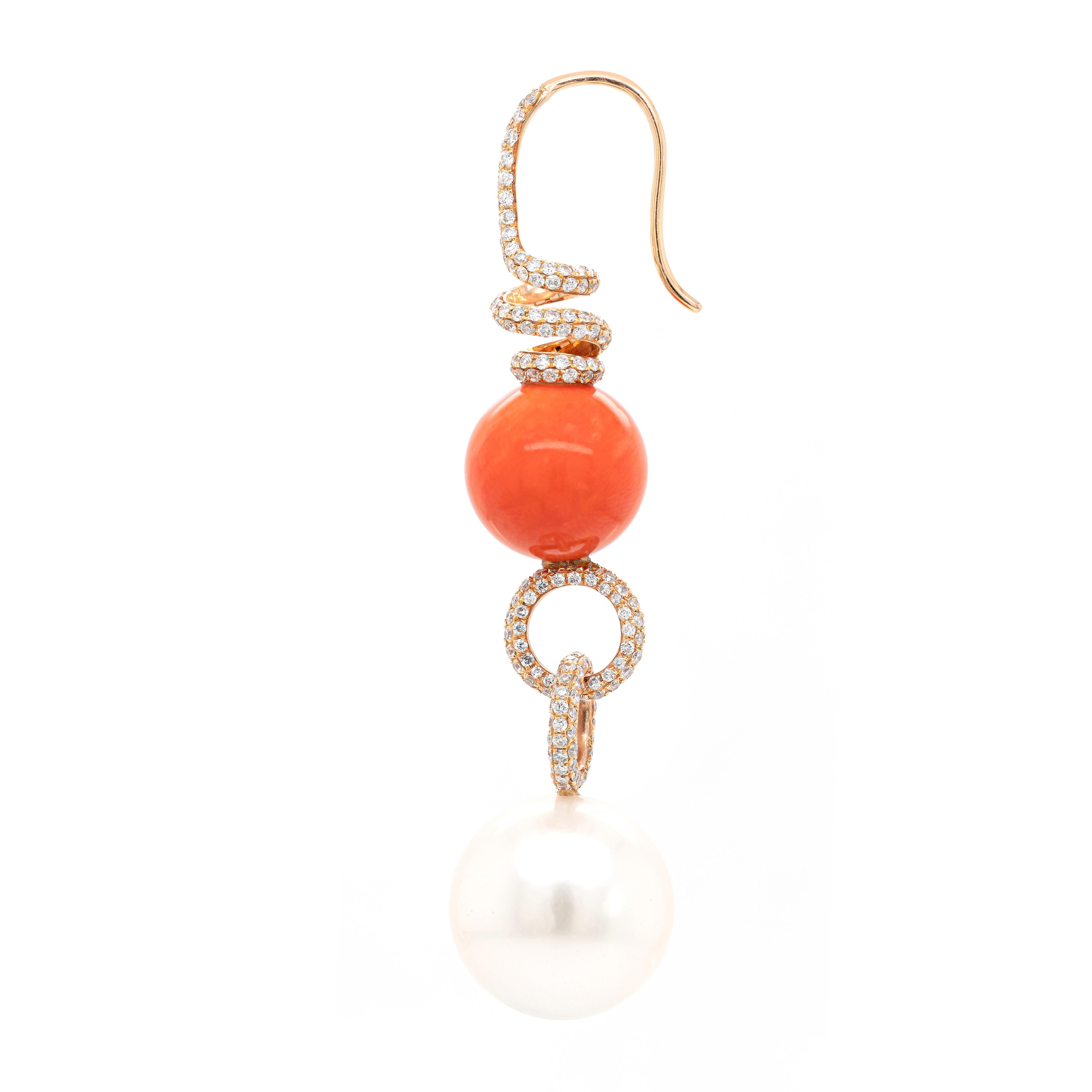 These gorgeous 18 carat rose gold drop earrings feature a round coral bead measuring 11.7mm and a cultured South Sea pearl measuring 14.4mm, which are beautifully connected by two rose gold circles micro set with round brilliant cut diamonds. The