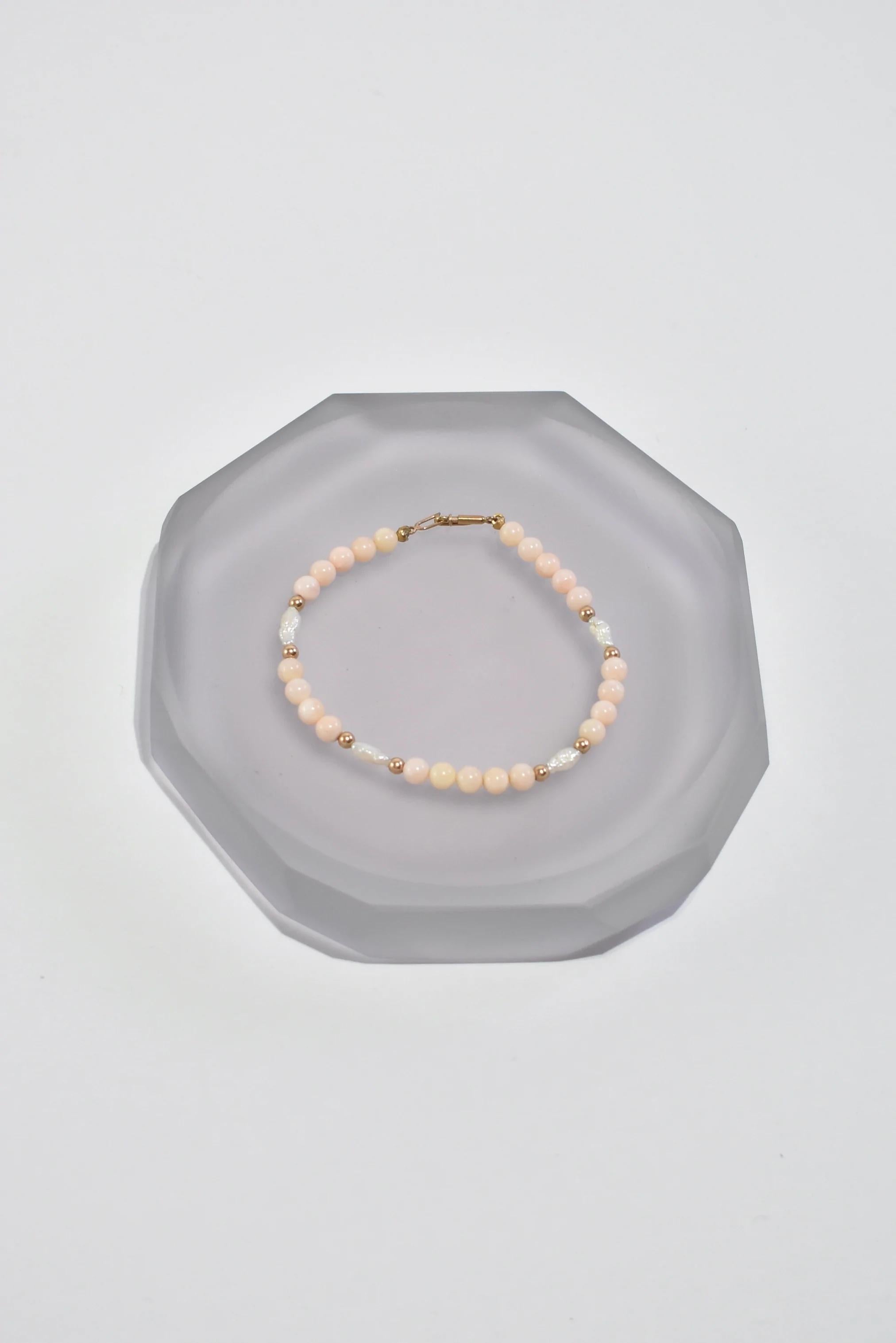 Vintage light pink coral bracelet with freshwater pearl and gold detail, clasp closure. Stamped 14k.

Material: 14k gold, coral, pearl.