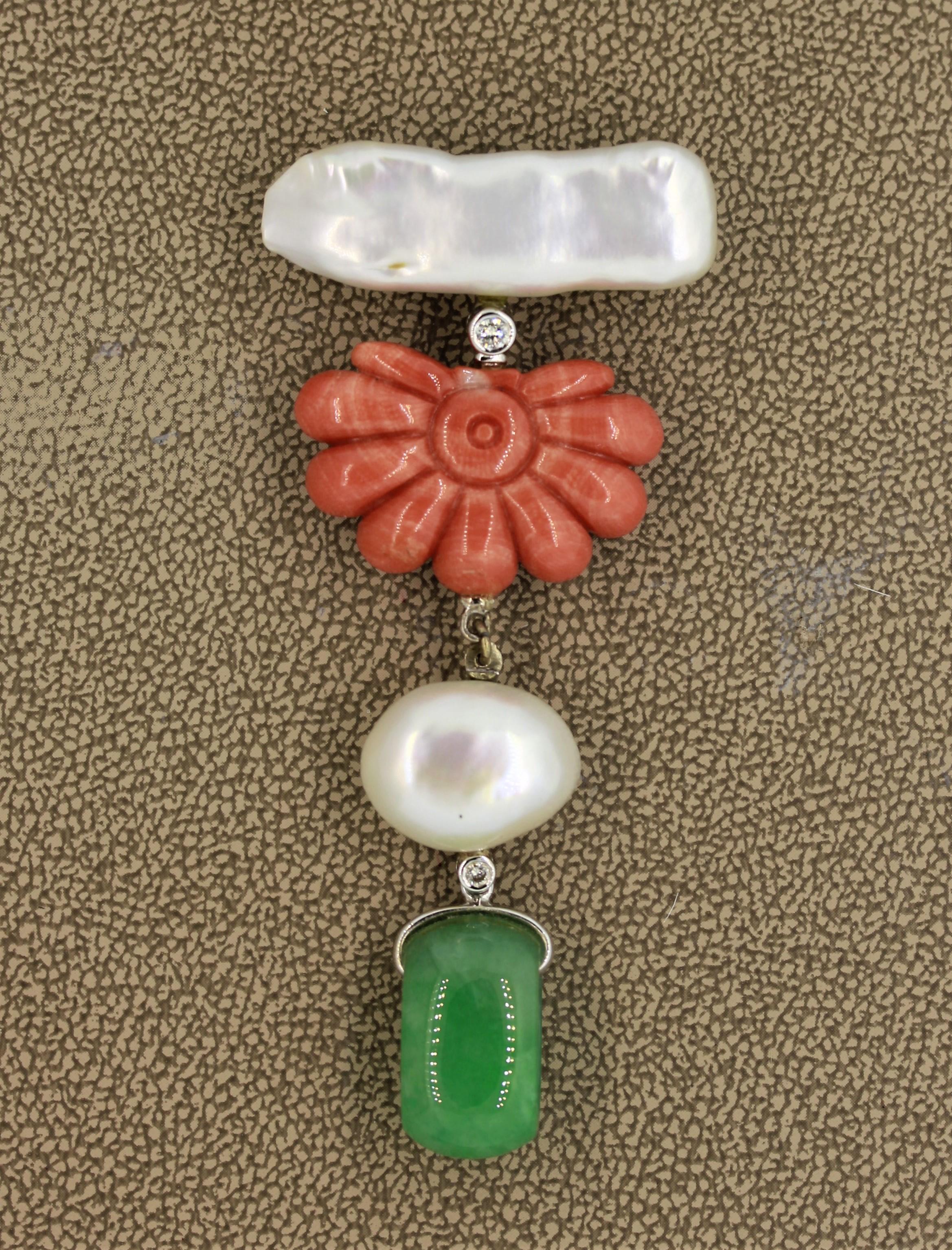 A unique brooch featuring natural materials which include 2 baroque pearls, 1 piece of hand carved coral, and a fine piece of green jadeite jade. They are accented by 2 round brilliant cut diamonds set in 18k white gold. The pieces as movement which