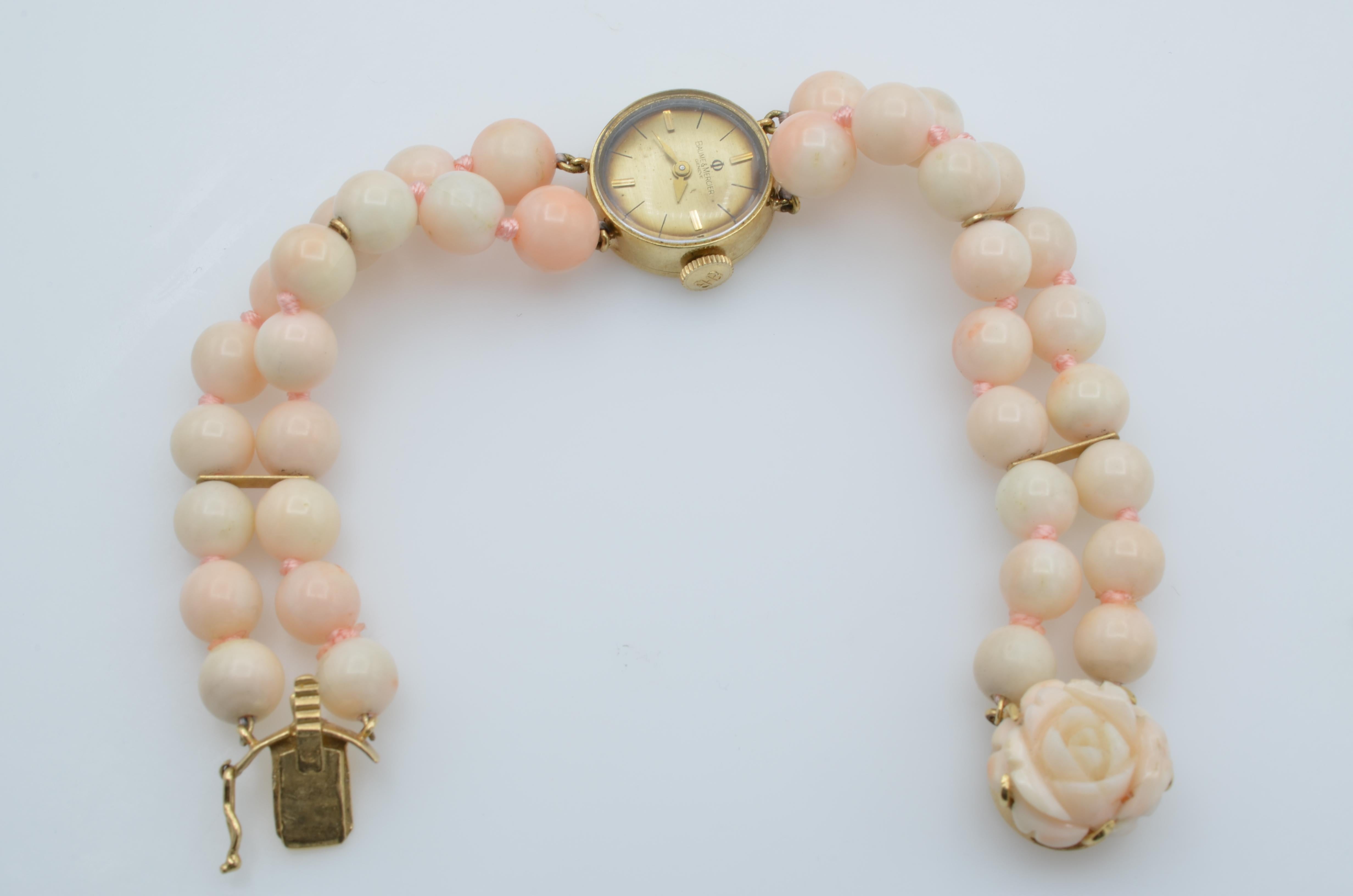 This lovely Baume et Mercier woman wrist watch mechanic beads coral 14 karat gold bracelet is two strands of Angel Skin coral hand knotted into a watch, movement set in 14k gold case. The clasp is a carved coral floral design with a secure safety.