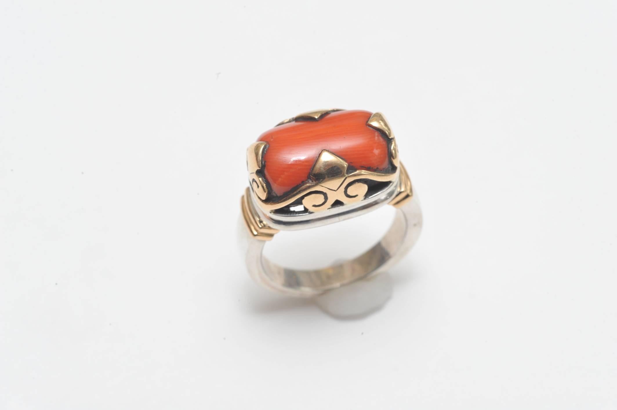 A fabulous combination of sterling silver and 18K gold--a weighted 18K, not plated.  Set with large Italian coral stone with great color in an unusual crown setting.  Ring size is 7.