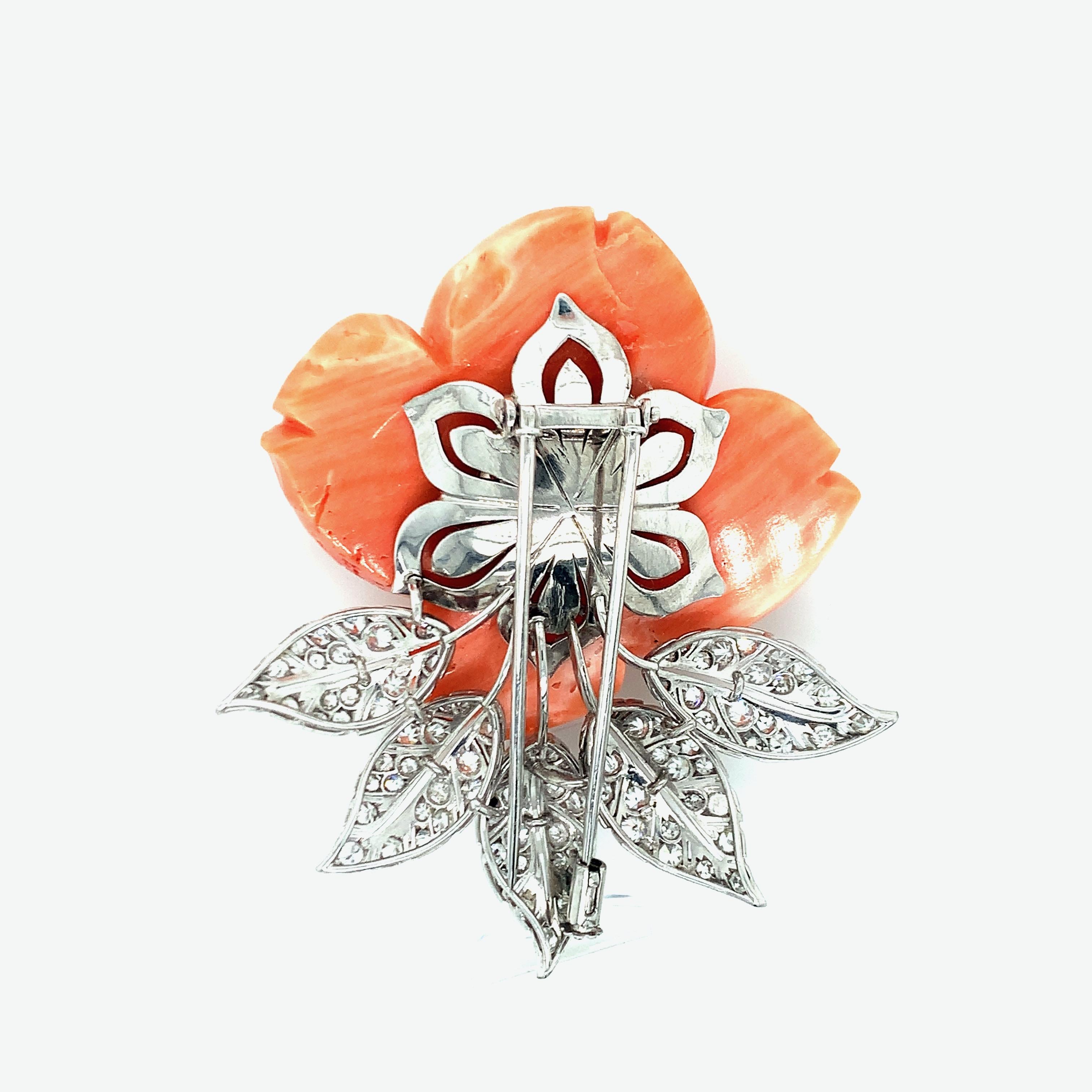 An eye-catching piece of jewelry, this brooch features a rose made of coral with diamonds weighing approximately 4 carats set in platinum leaves. Total weight: 38.4 grams. Length: 2.5 inches. Width: 2.13 inches. 