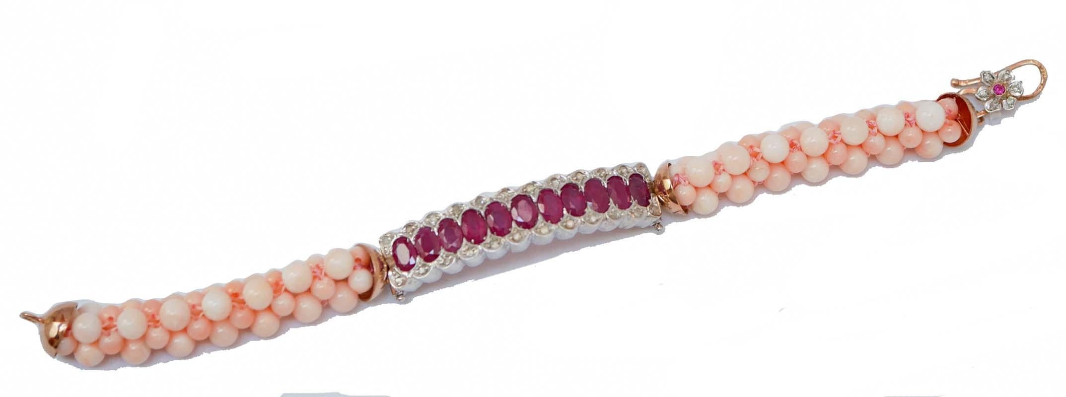 Amazing bracelet mounted with a central structure in 9 kt rose gold and silver studded with rubies and diamonds. Laterally, corals.  As closure, a flower mounted with diamonds and a ruby.
This bracelet was totally handmade by Italian master