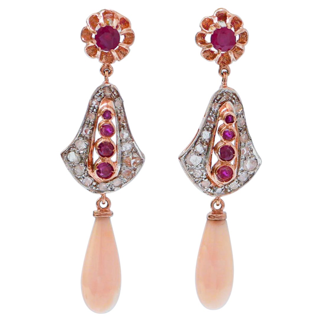 Orecchini con corallo, rubini, diamanti, oro rosa e argento.