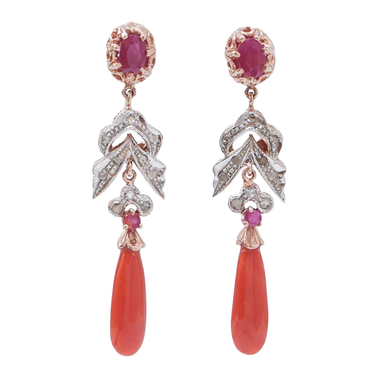 Orecchini con corallo, rubini, diamanti, oro rosa e argento.