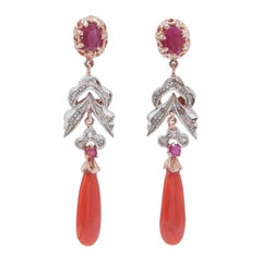Orecchini con corallo, rubini, diamanti, oro rosa e argento.