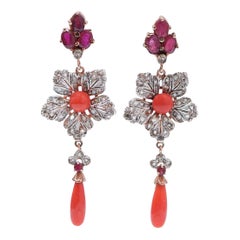 Ohrringe mit Korallen, Rubinen, Diamanten, in Roségold und Silber.
