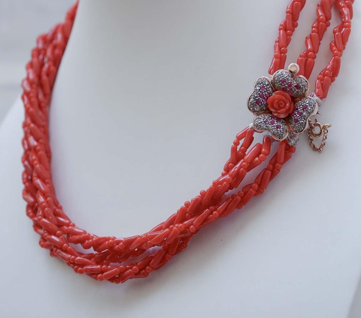 Fantastic retrò necklace mounted with three strands of coral and, as clasp, a flowe in 9 kt rose gold and silver structure mounted with a flower of coral in the central part surrounded by diamonds and rubies.
This necklace was totally handmade by